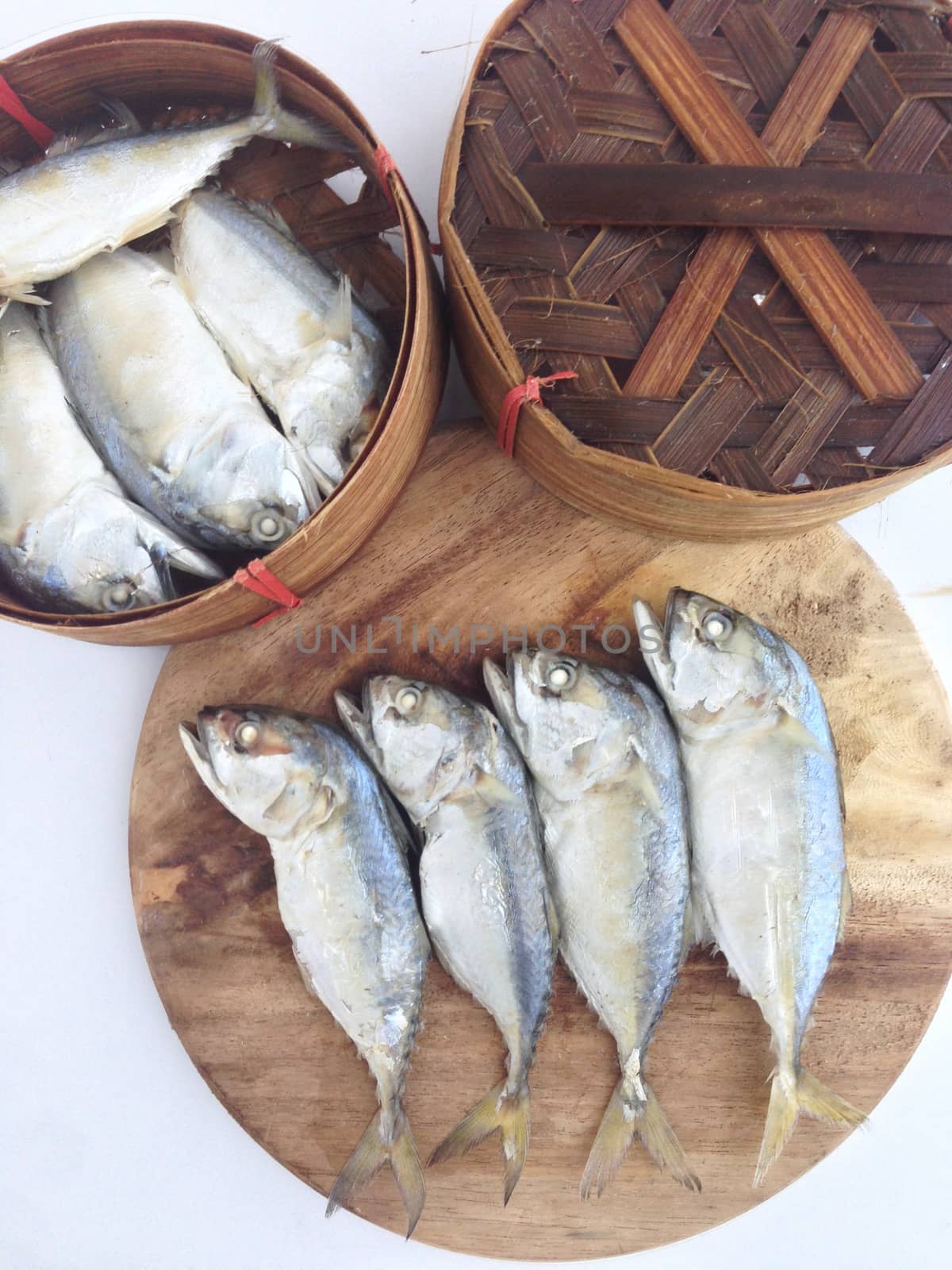 short mackerel on cutting board with fish basket by Bowonpat
