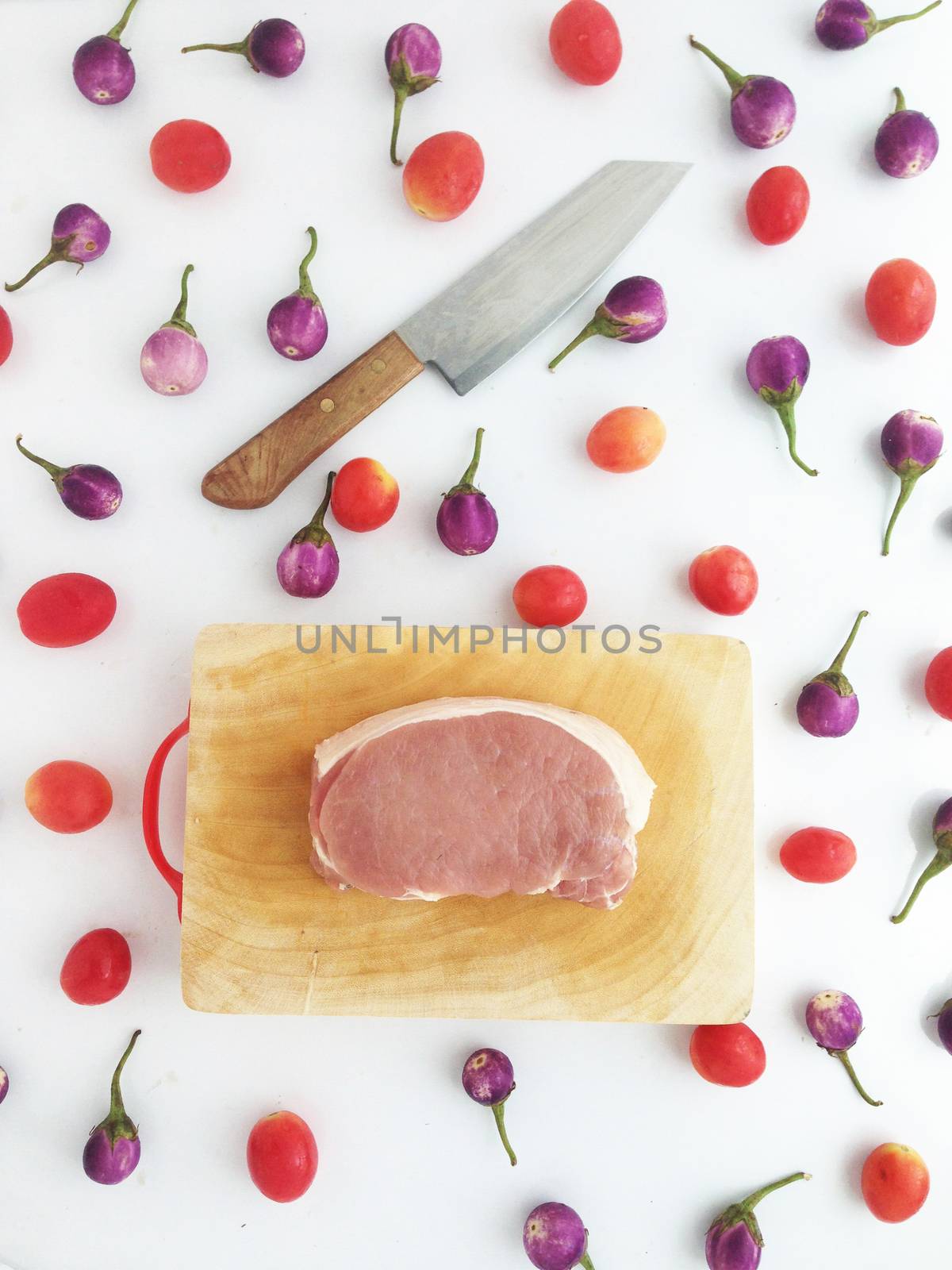 Pork on cutting board with tomatoes and  Thai eggplants by Bowonpat