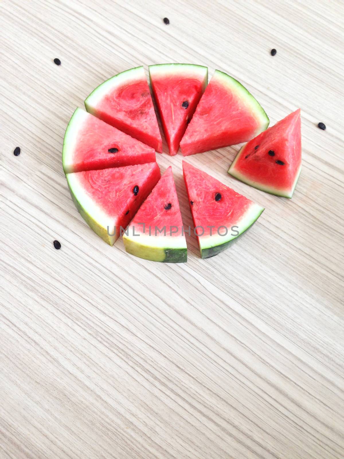 slices of watermelon look like cake on Wooden floor by Bowonpat