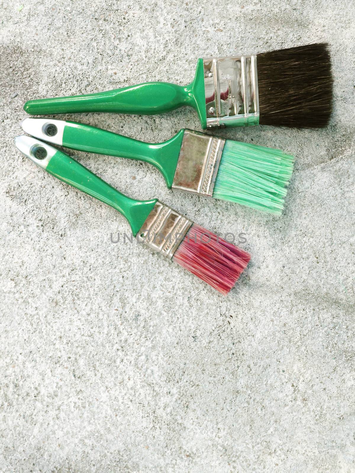 Paint brush on cement floor
 by Bowonpat
