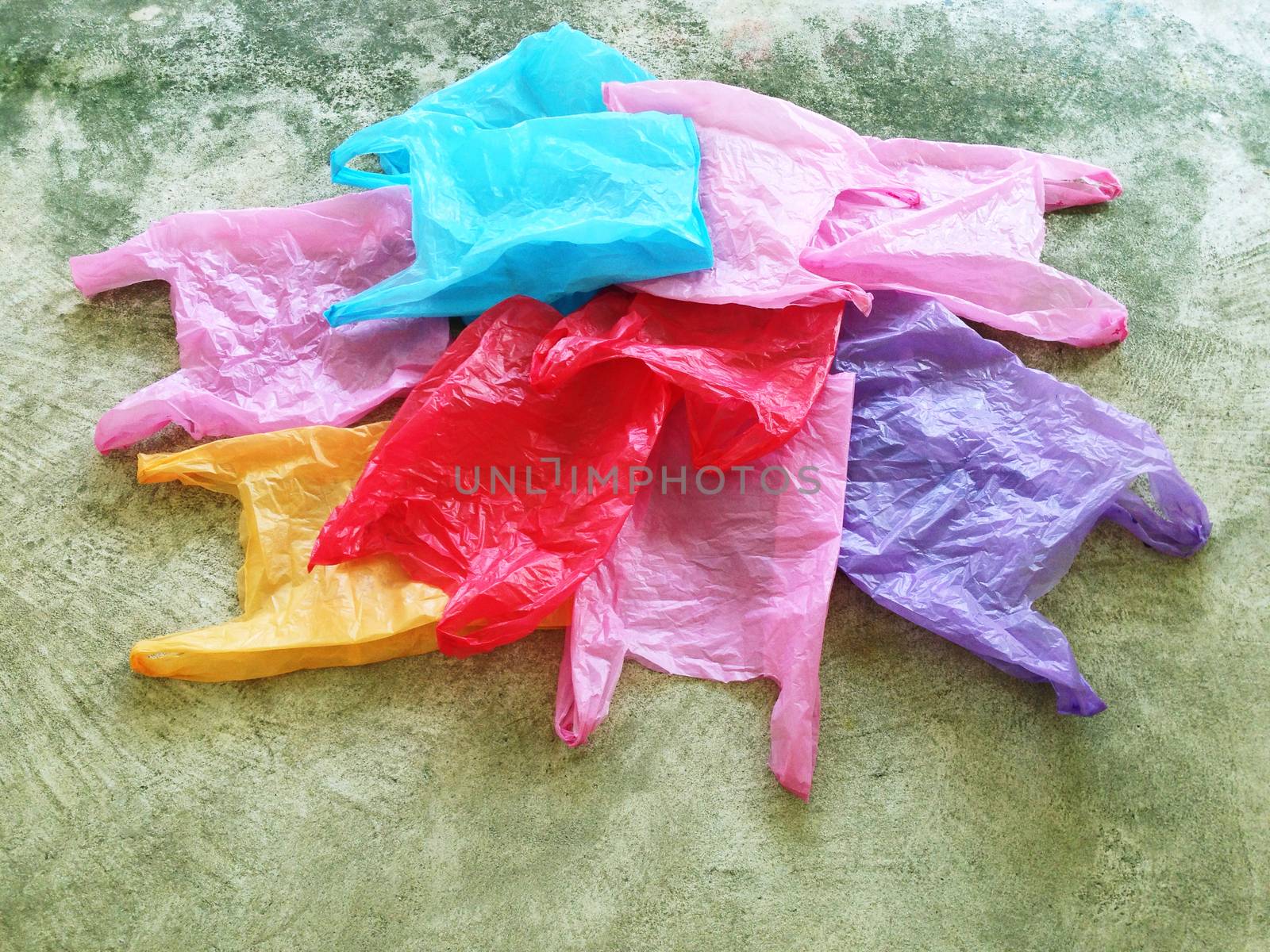 Colorful plastic bag on cement floor by Bowonpat