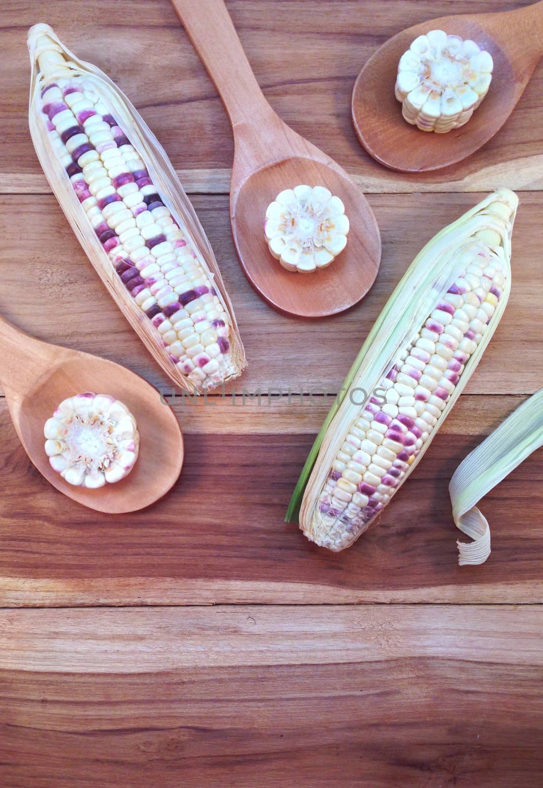 White and purple corn with rice wooden ladle on wooden backgroun by Bowonpat