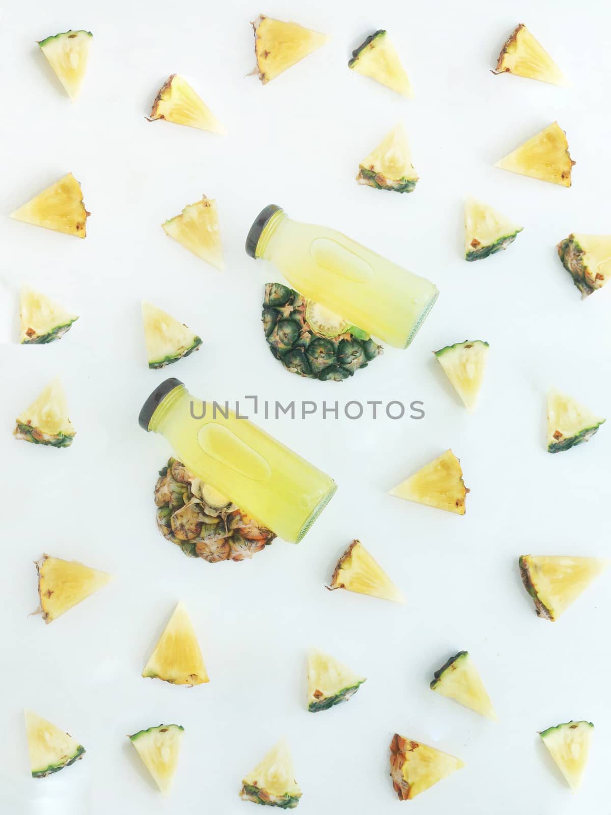 Fresh and cold pineapple drink among triangular piece of pineapp by Bowonpat