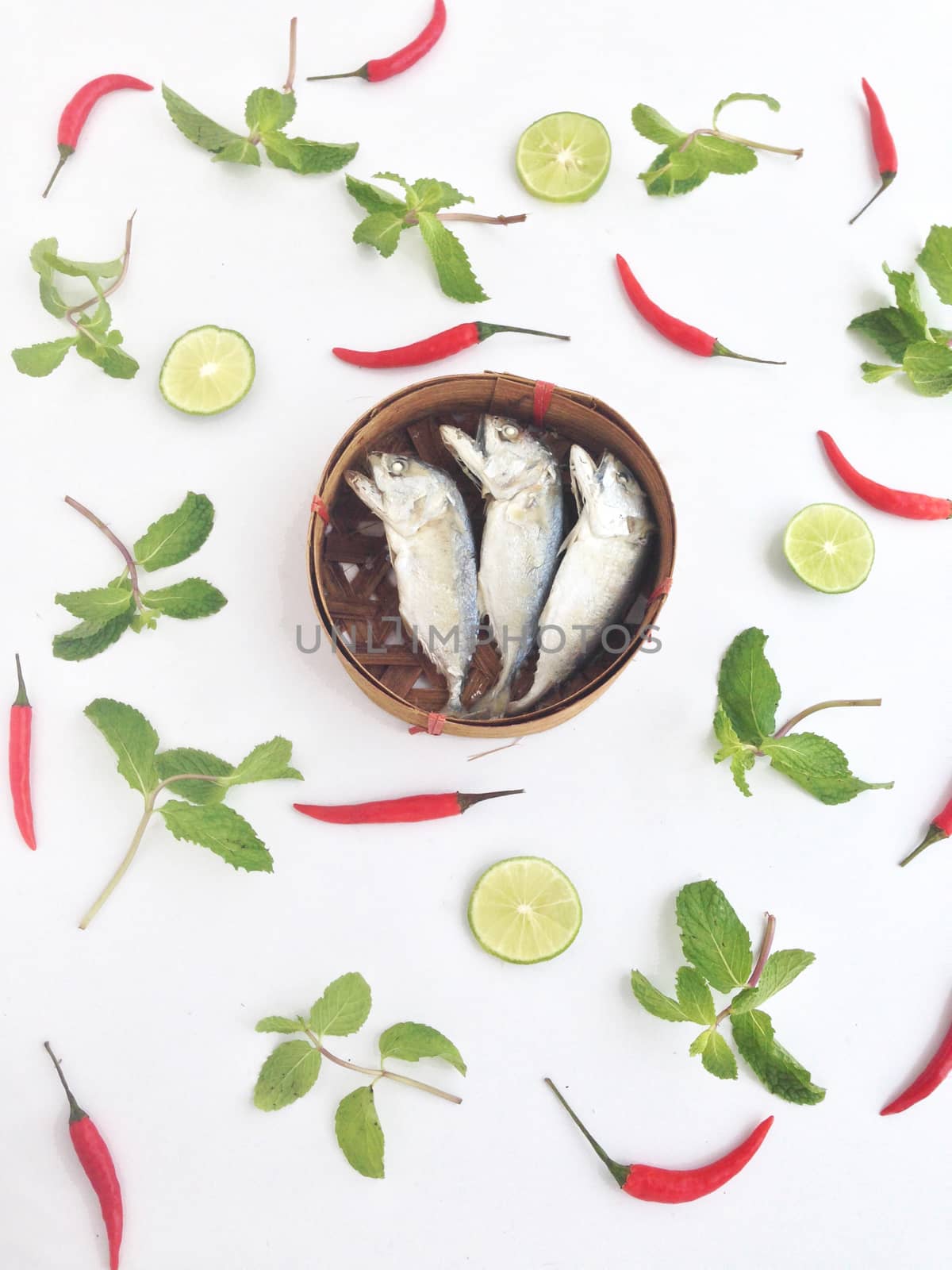 short mackerel on fish basket with chili paper mint and lime by Bowonpat