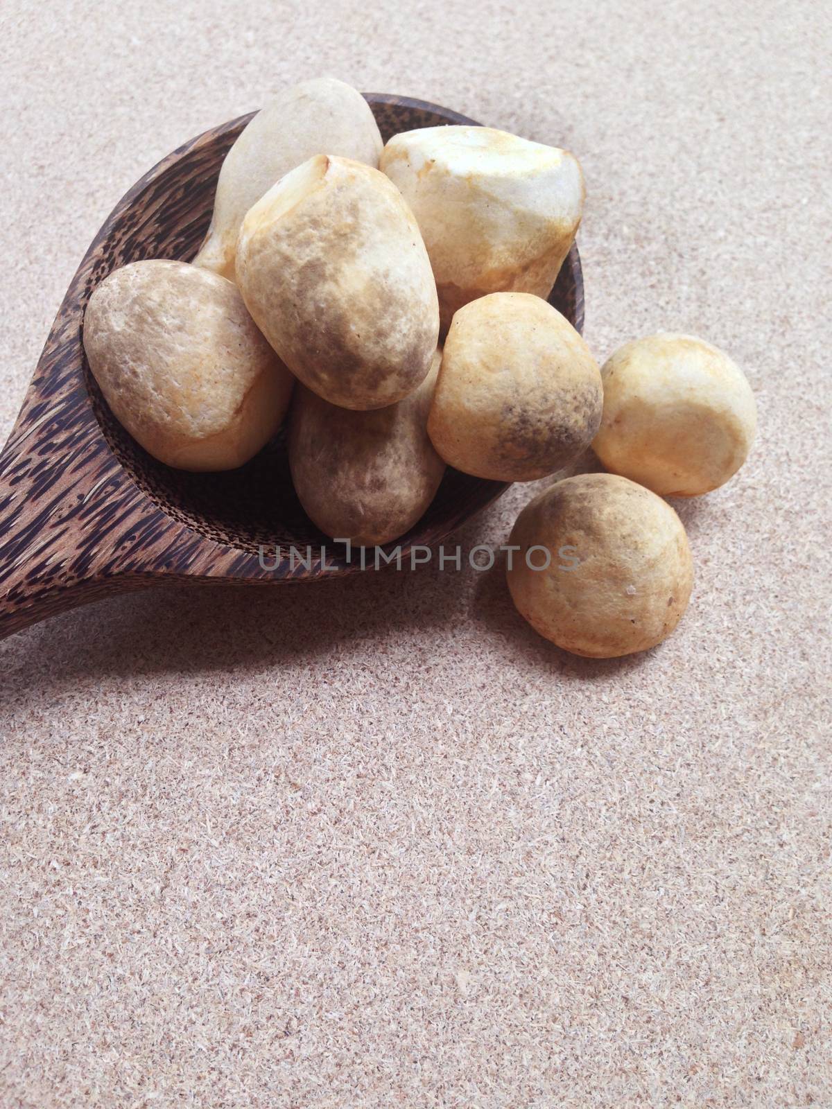 Straw mushroom with wooden spoon on plywood background by Bowonpat