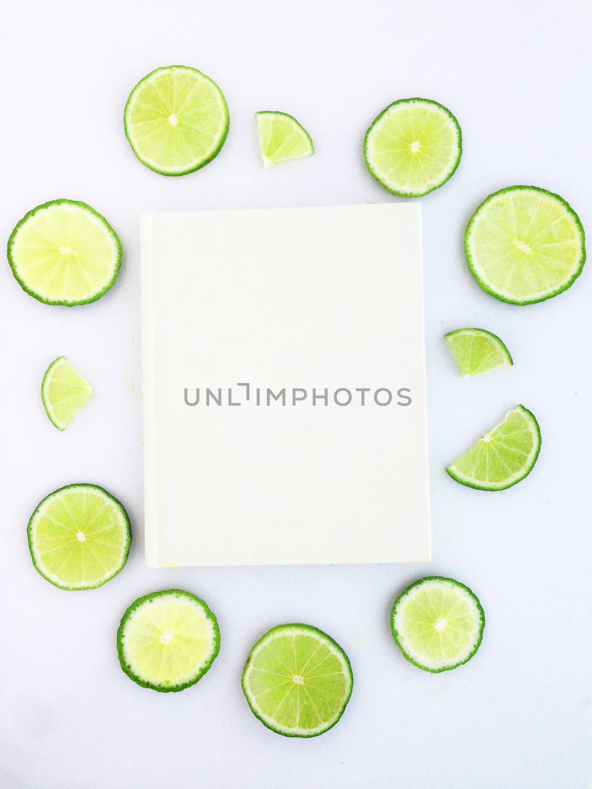 diary with lime slice on white background by Bowonpat