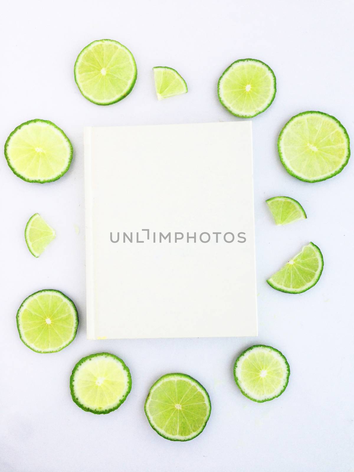 diary with lime slice on white background