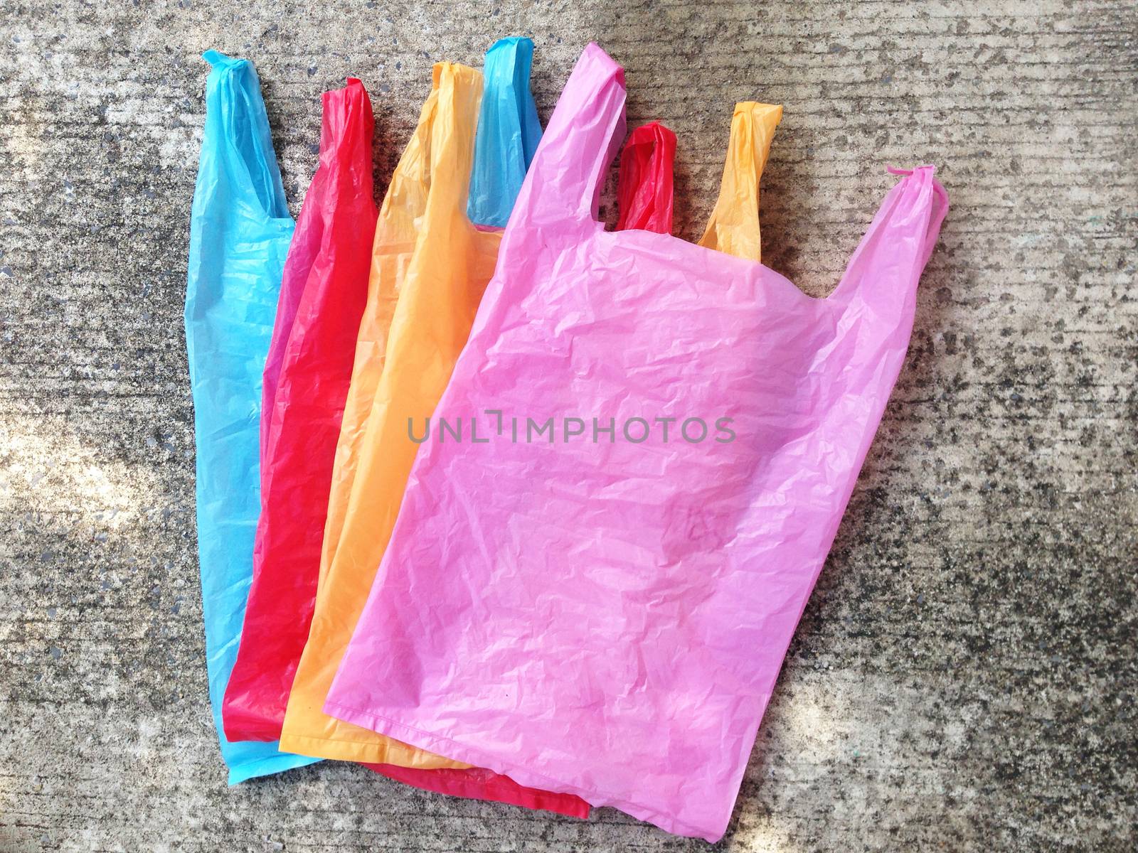 Colorful plastic bag on cement floor by Bowonpat