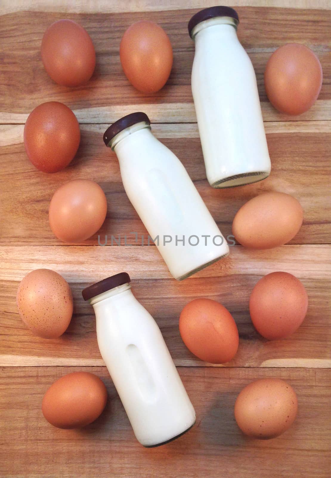 Eggs with bottle of milk on wooden background by Bowonpat