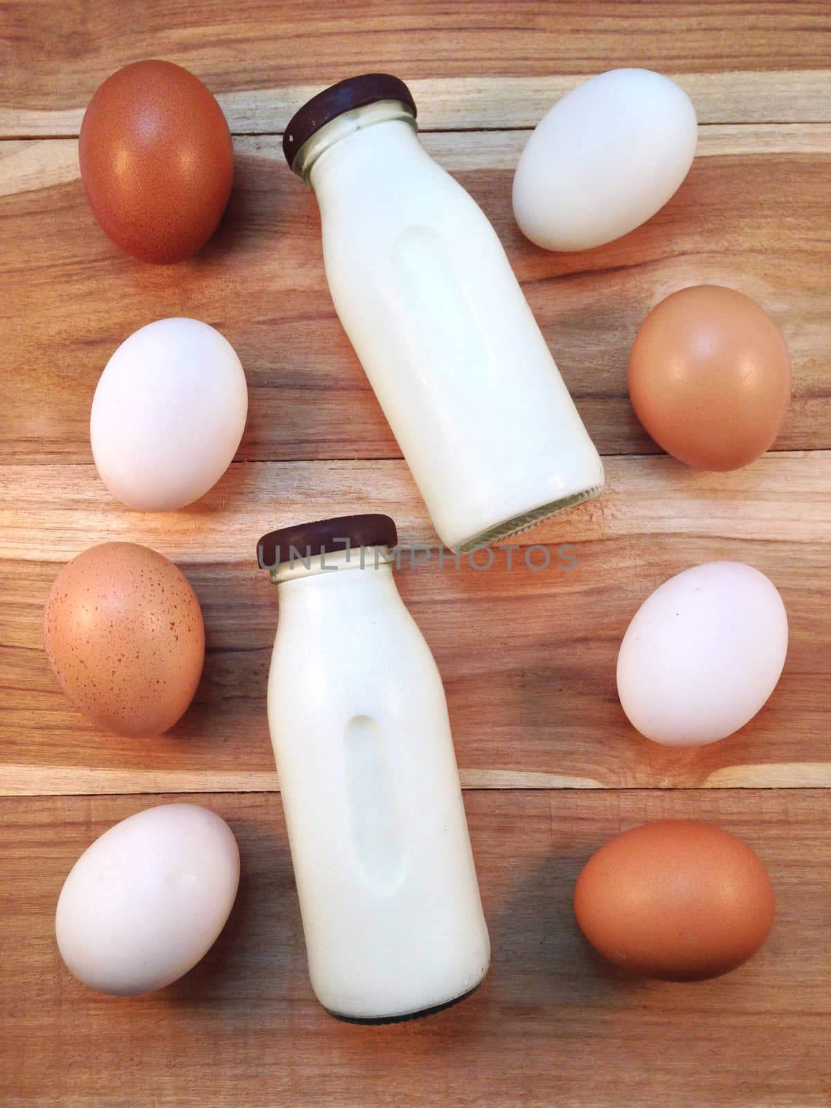 Eggs with bottle of milk on wooden background