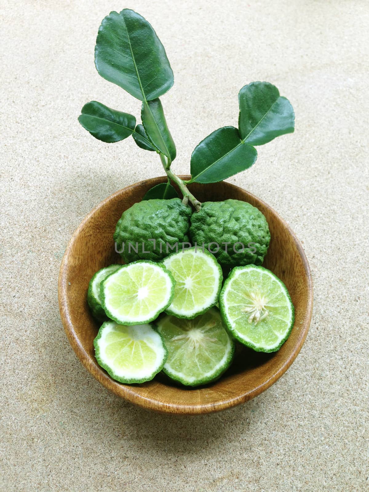 Kaffir Lime or Bergamot in wooden bowl on plywood background