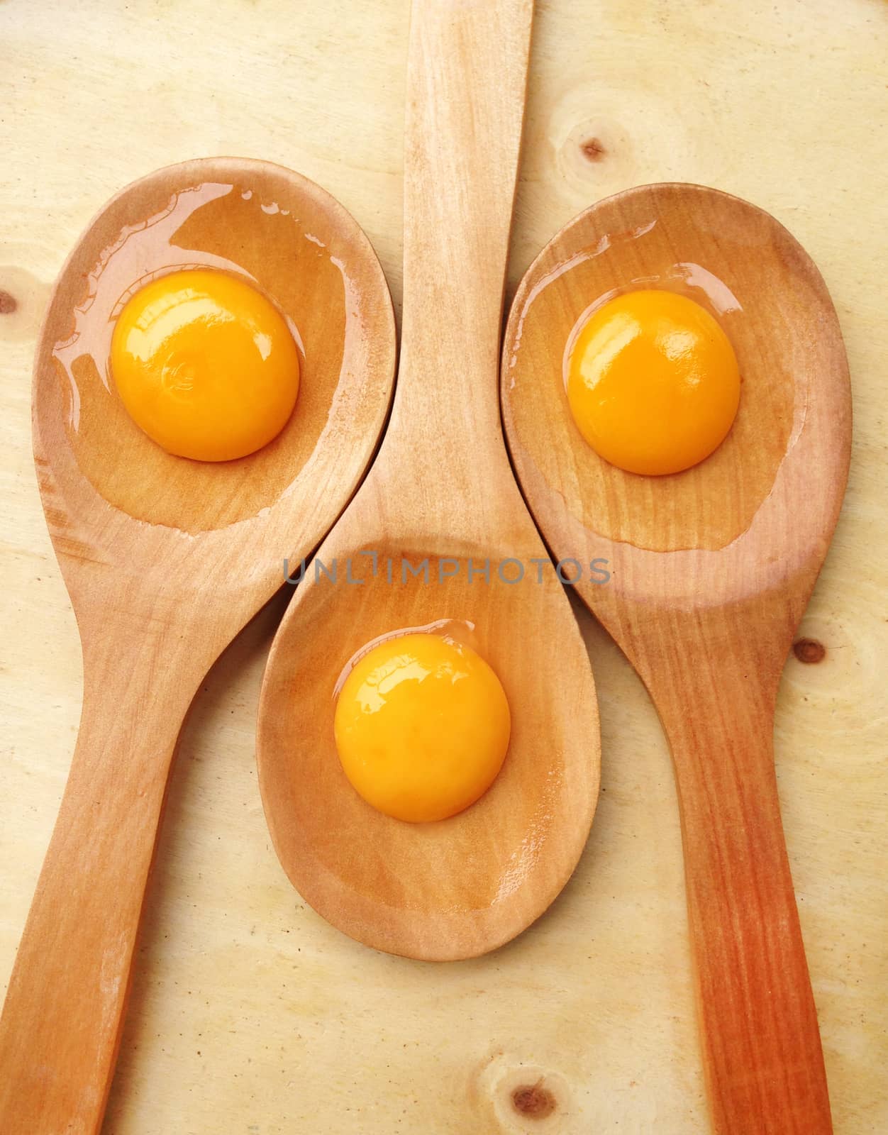 York eggs on wooden ladle on wooden background