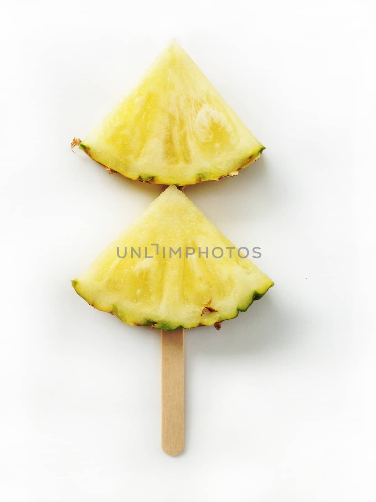 Pineapple slices isolated with popsicle sticks on white background