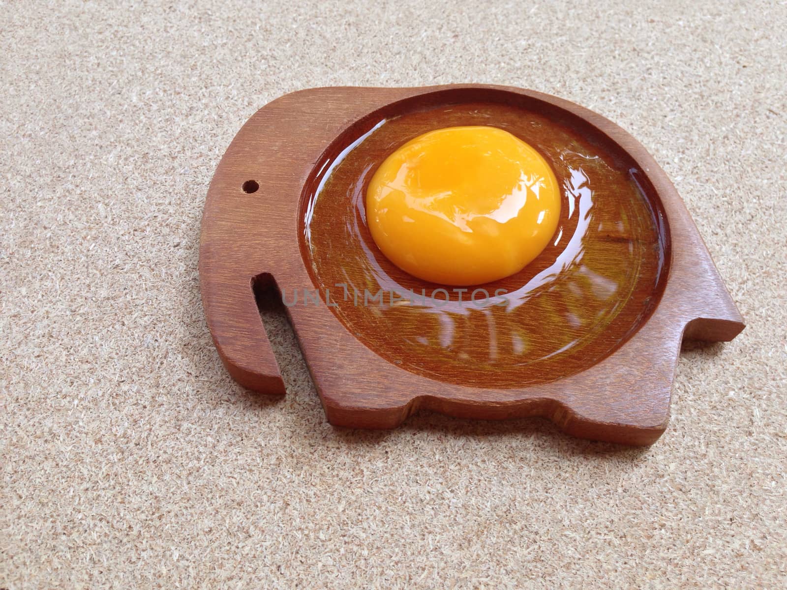 Egg on wooden elephant shaped saucer