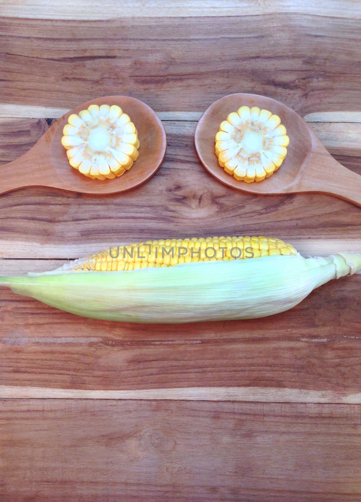 Corn on wooden background by Bowonpat