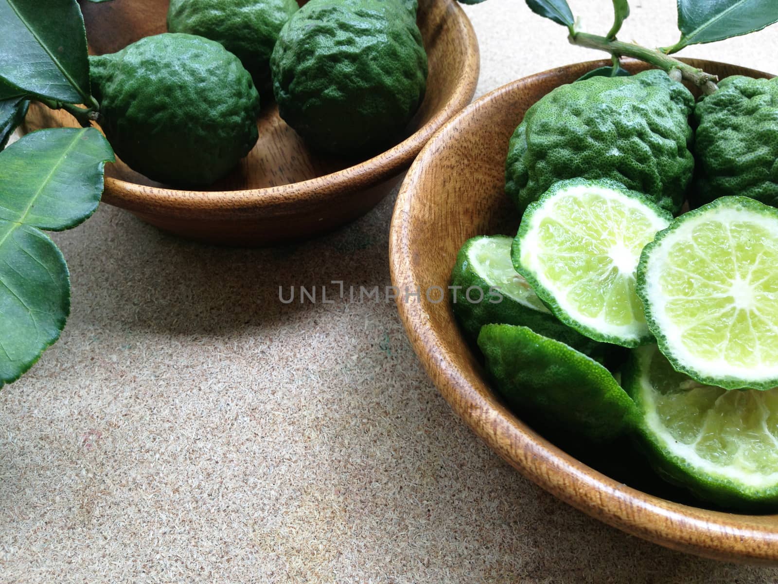 Kaffir Lime or Bergamot in wooden bowl on plywood background