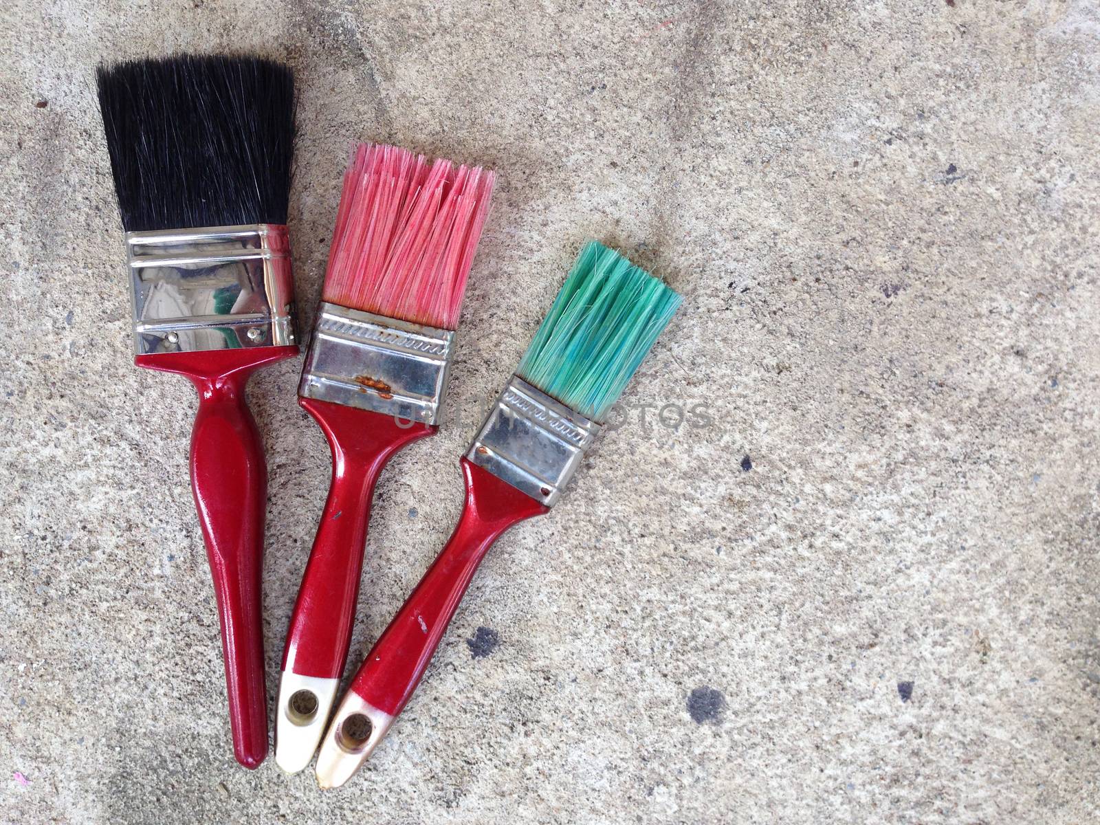 Paint brush on cement floor
 by Bowonpat