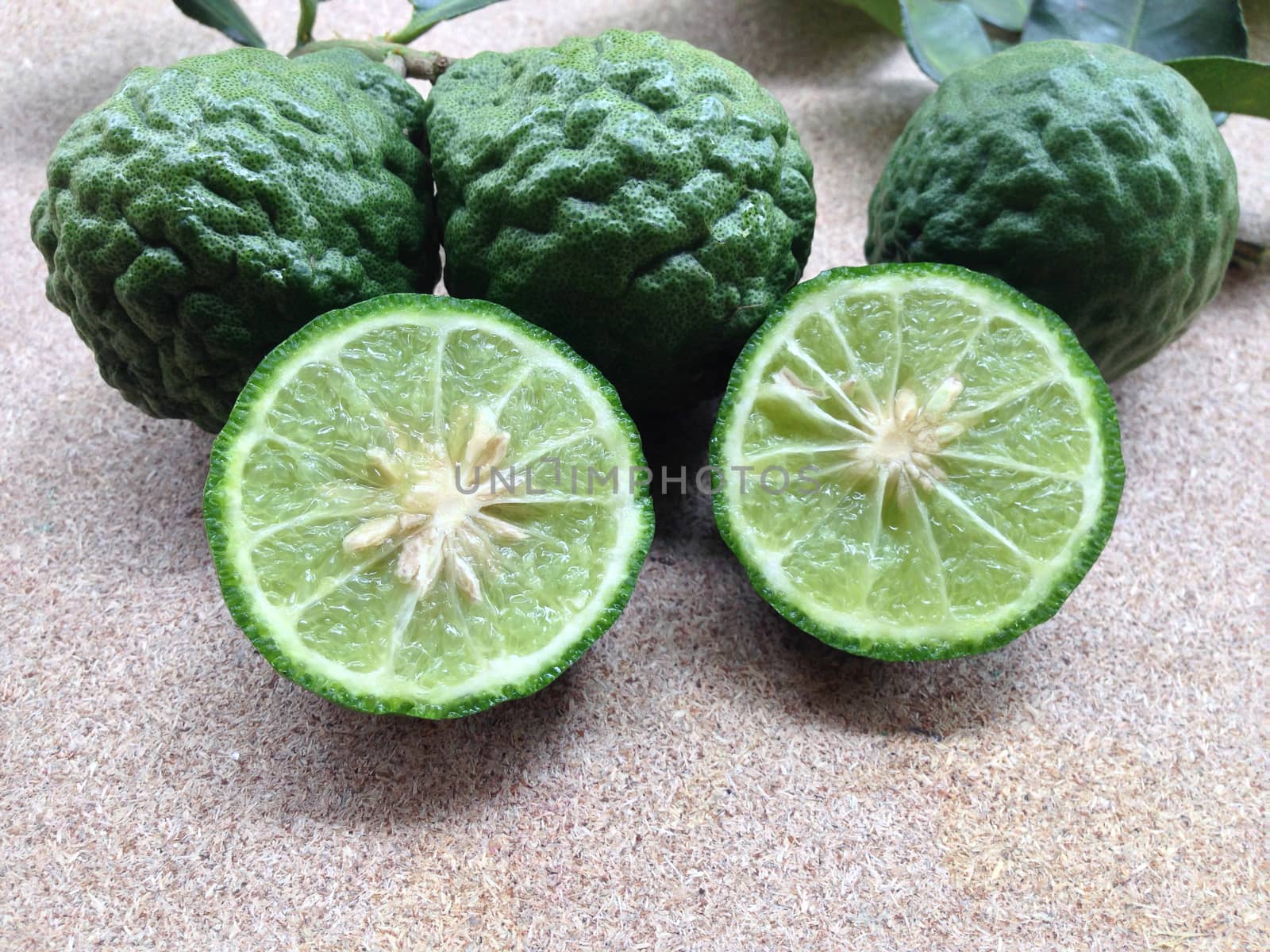 Kaffir Lime or Bergamot on plywood background by Bowonpat