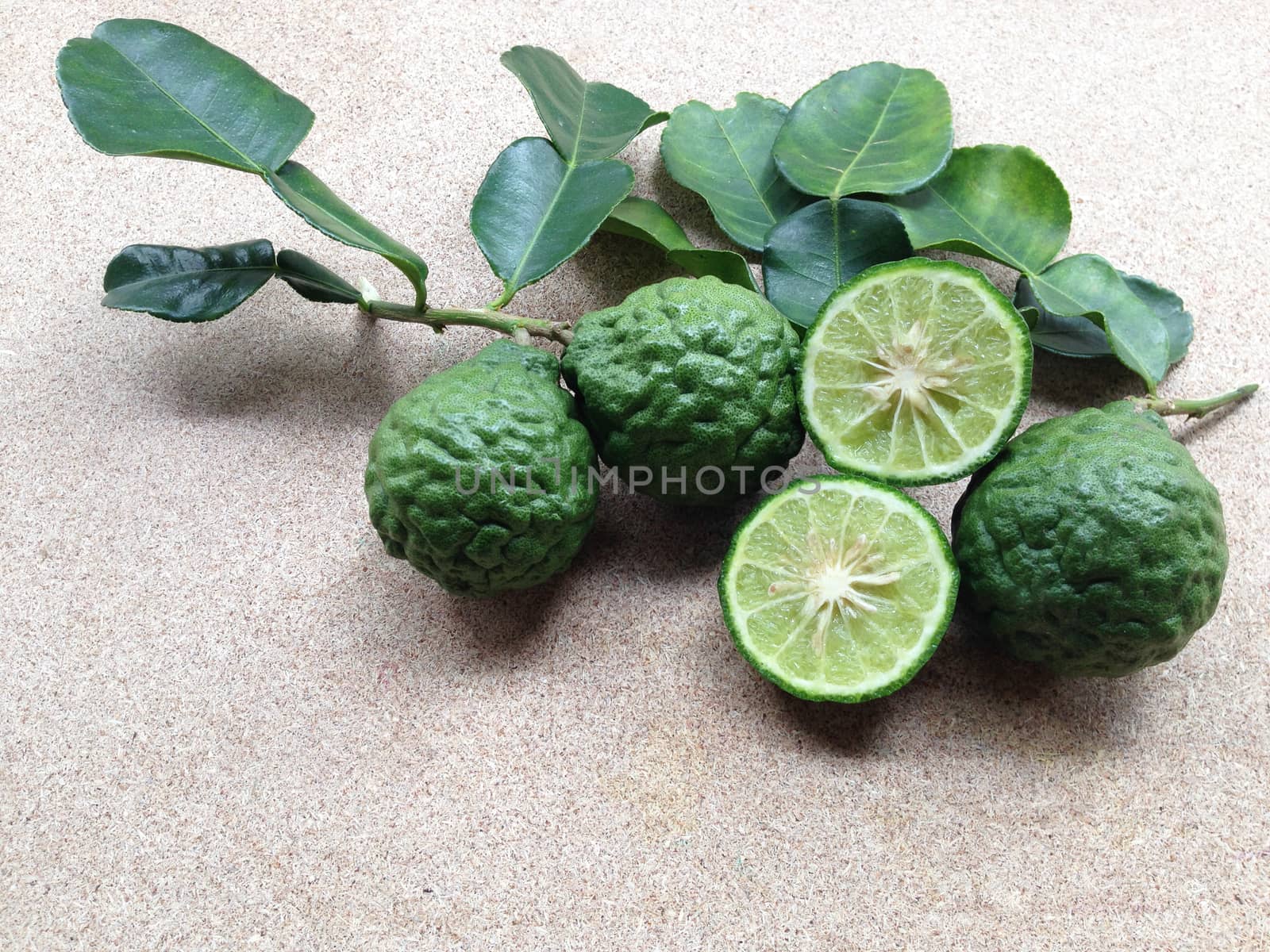 Kaffir Lime or Bergamot on plywood background by Bowonpat