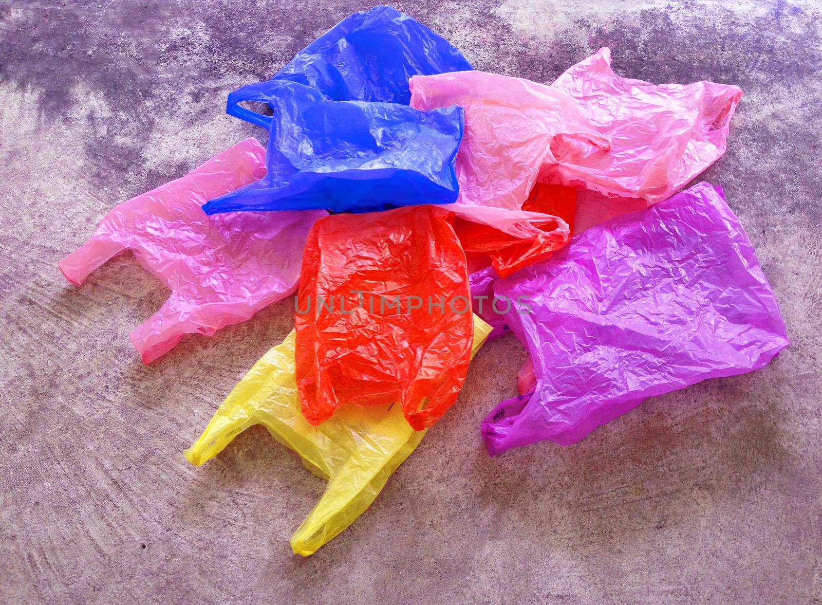 Colorful plastic bag on cement floor by Bowonpat