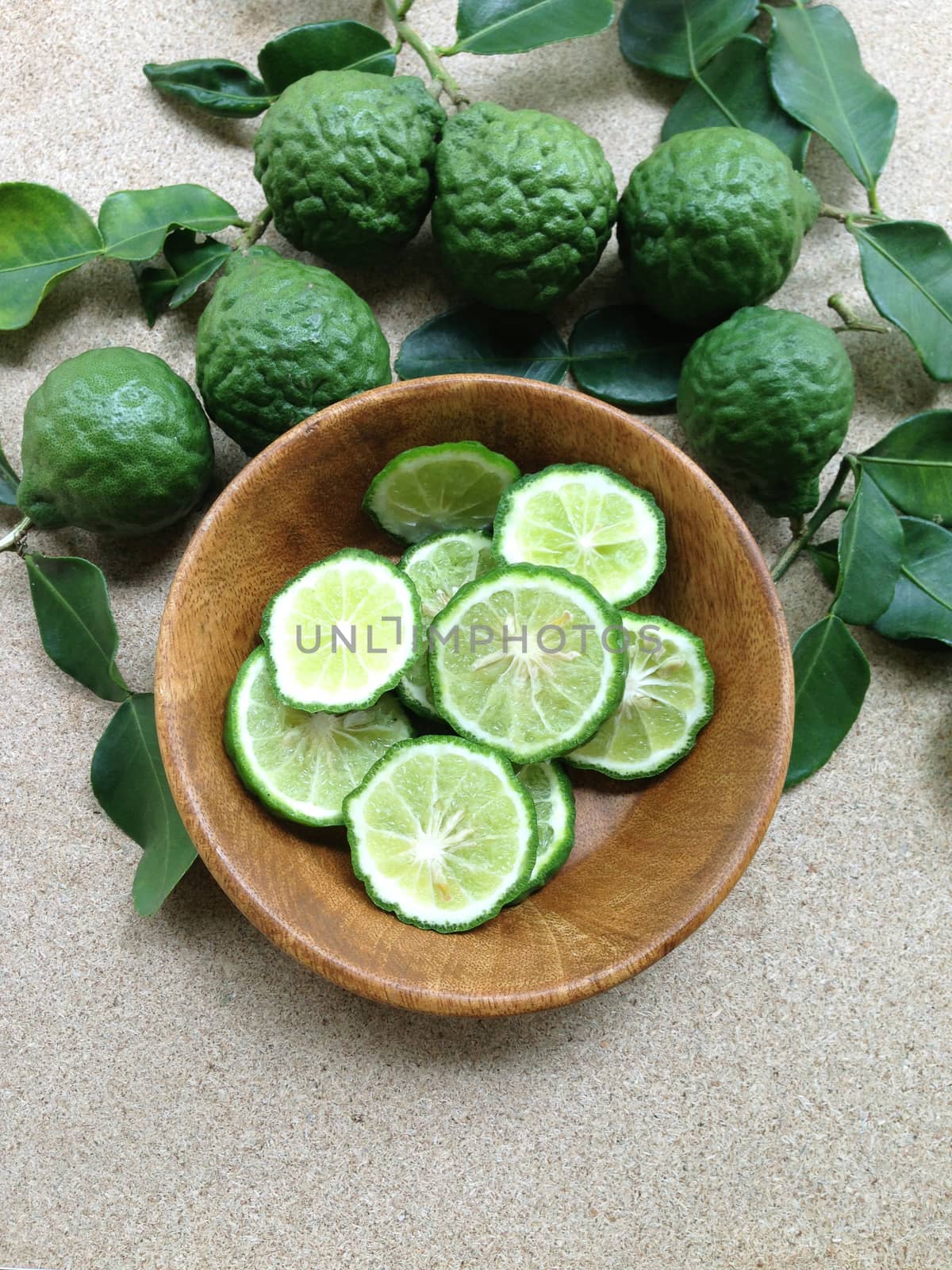 Kaffir Lime or Bergamot in wooden bowl on plywood background