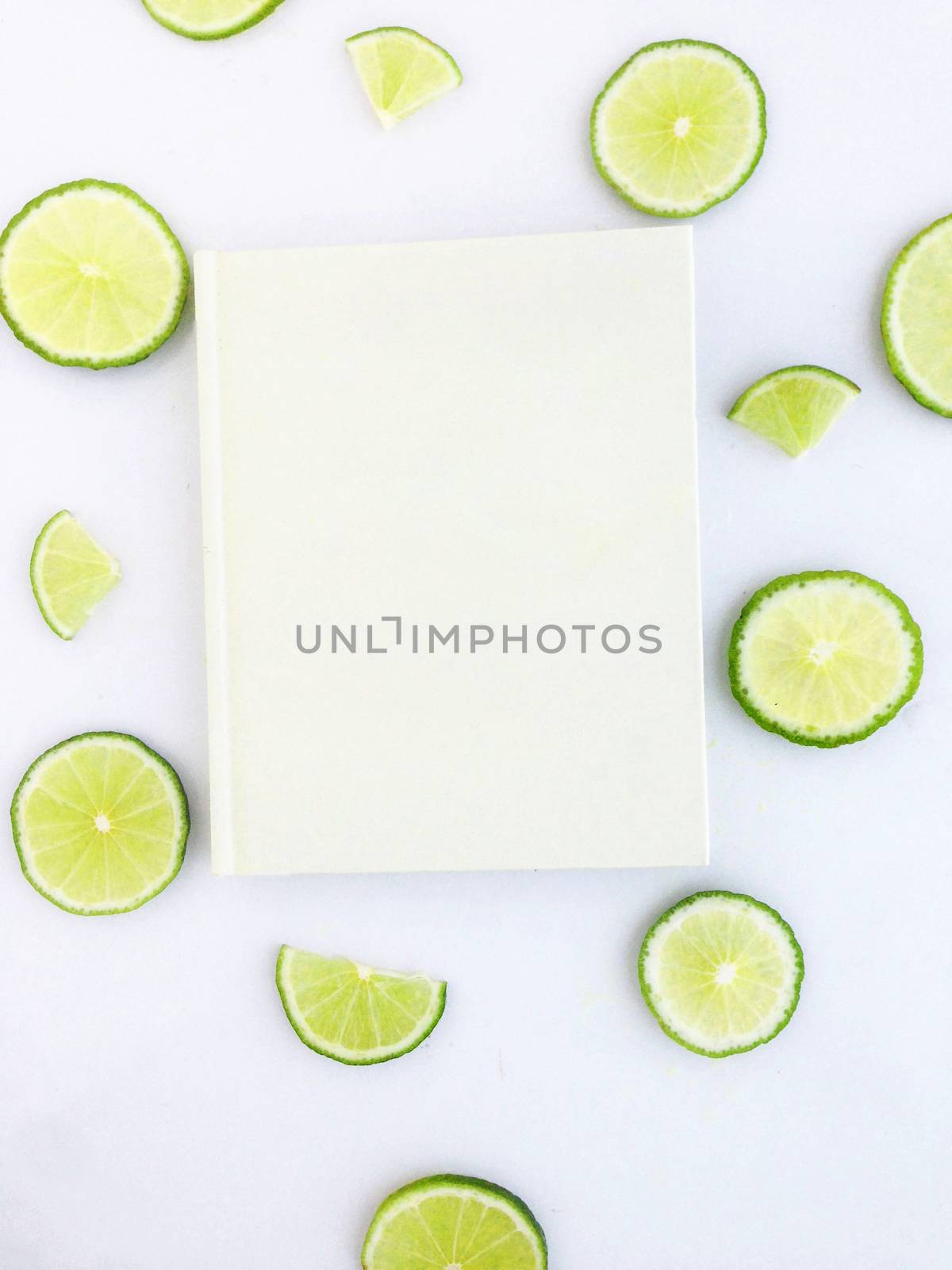 diary with lime slice on white background by Bowonpat