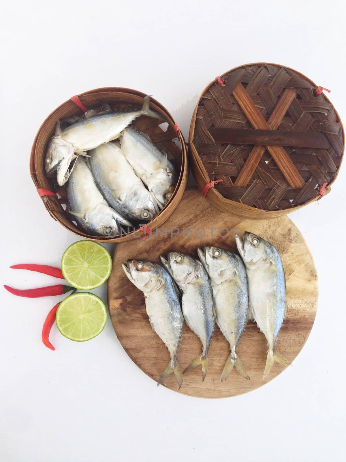 short mackerel on cutting board with fish basket by Bowonpat