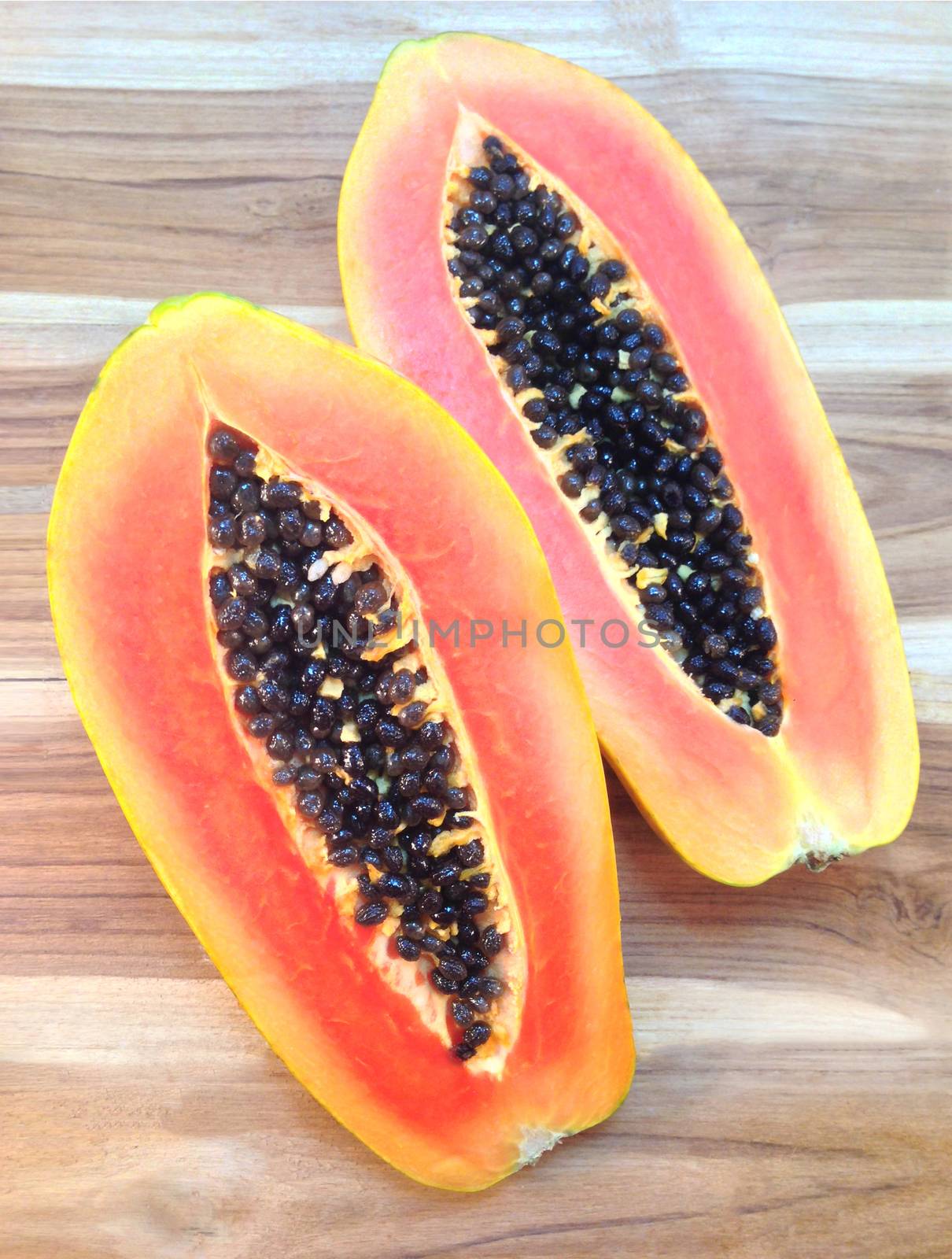 slices of sweet papaya on wooden background by Bowonpat