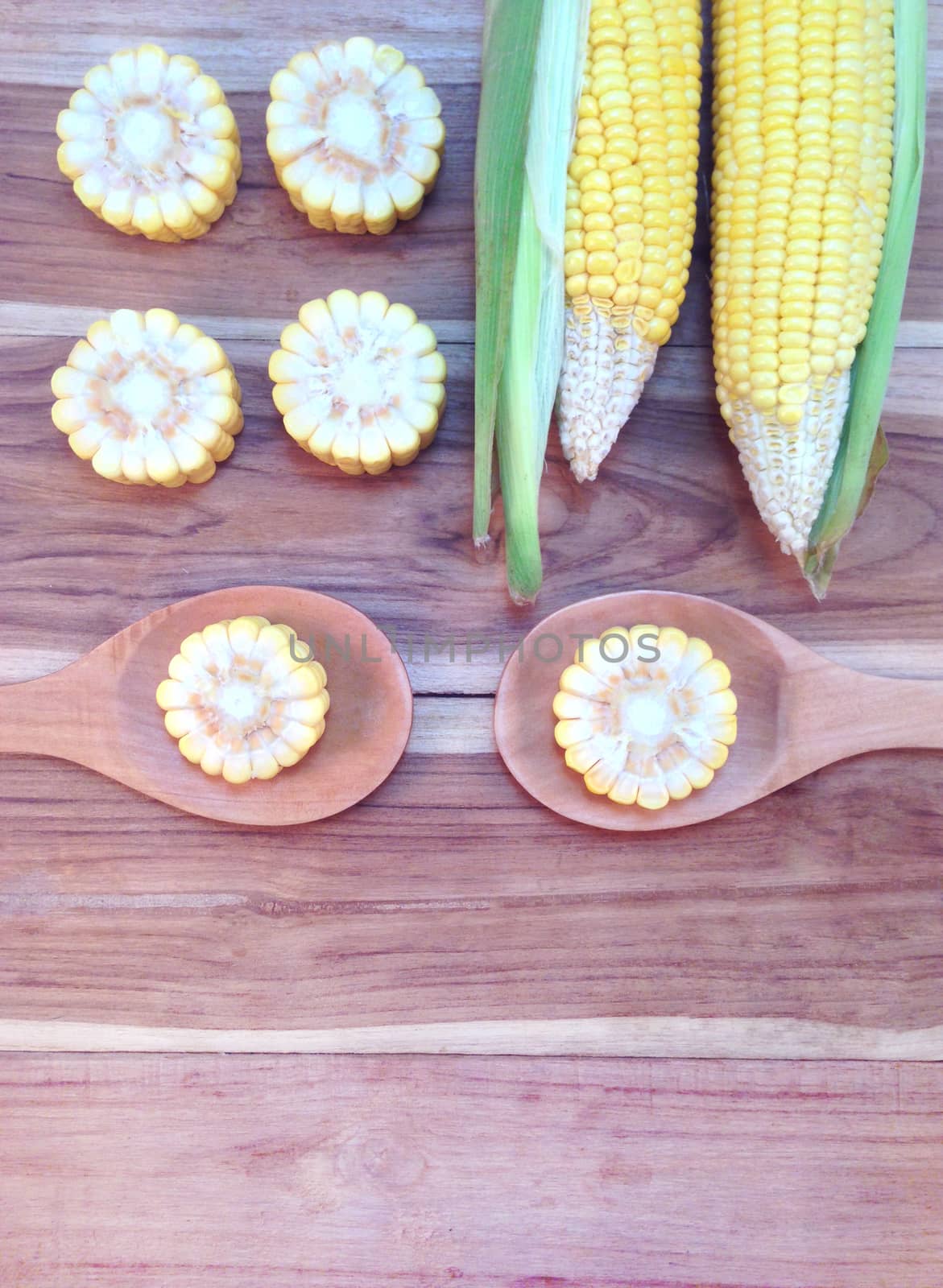 Corn on wooden background by Bowonpat