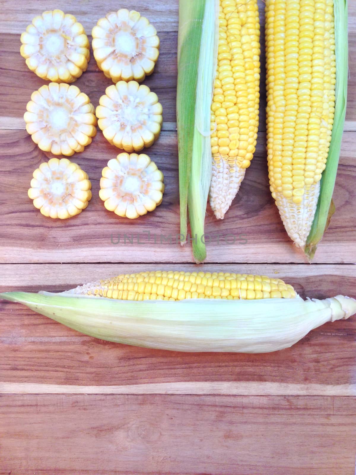 Corn on wooden background by Bowonpat