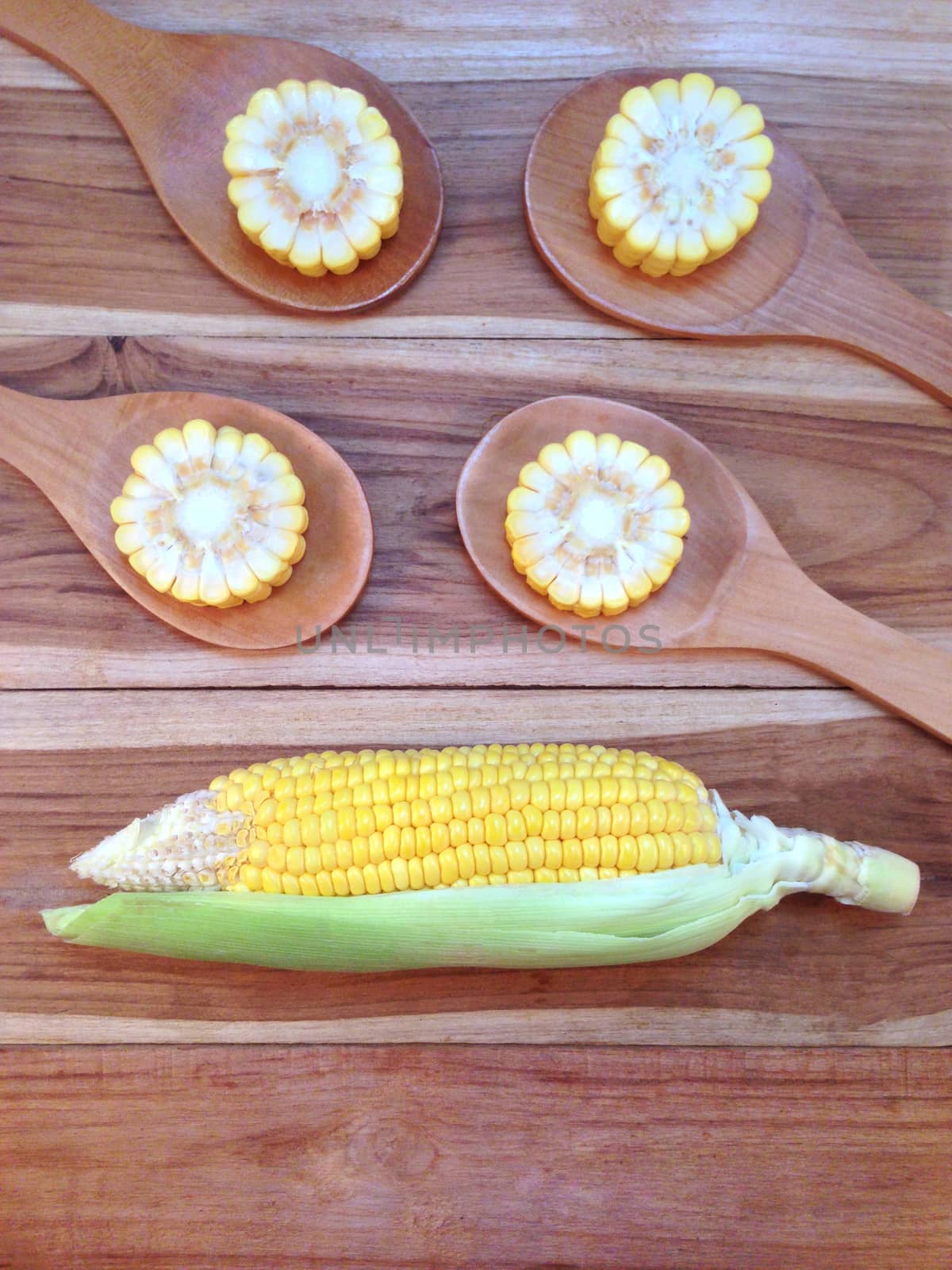 Corn on wooden background by Bowonpat