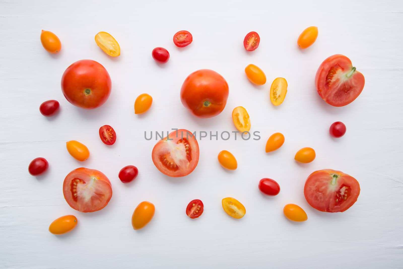 variety tomatoes on white wooden background. by Bowonpat