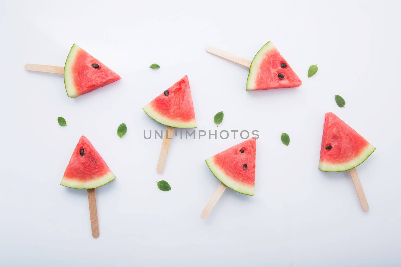 Watermelon slice popsicles on white background