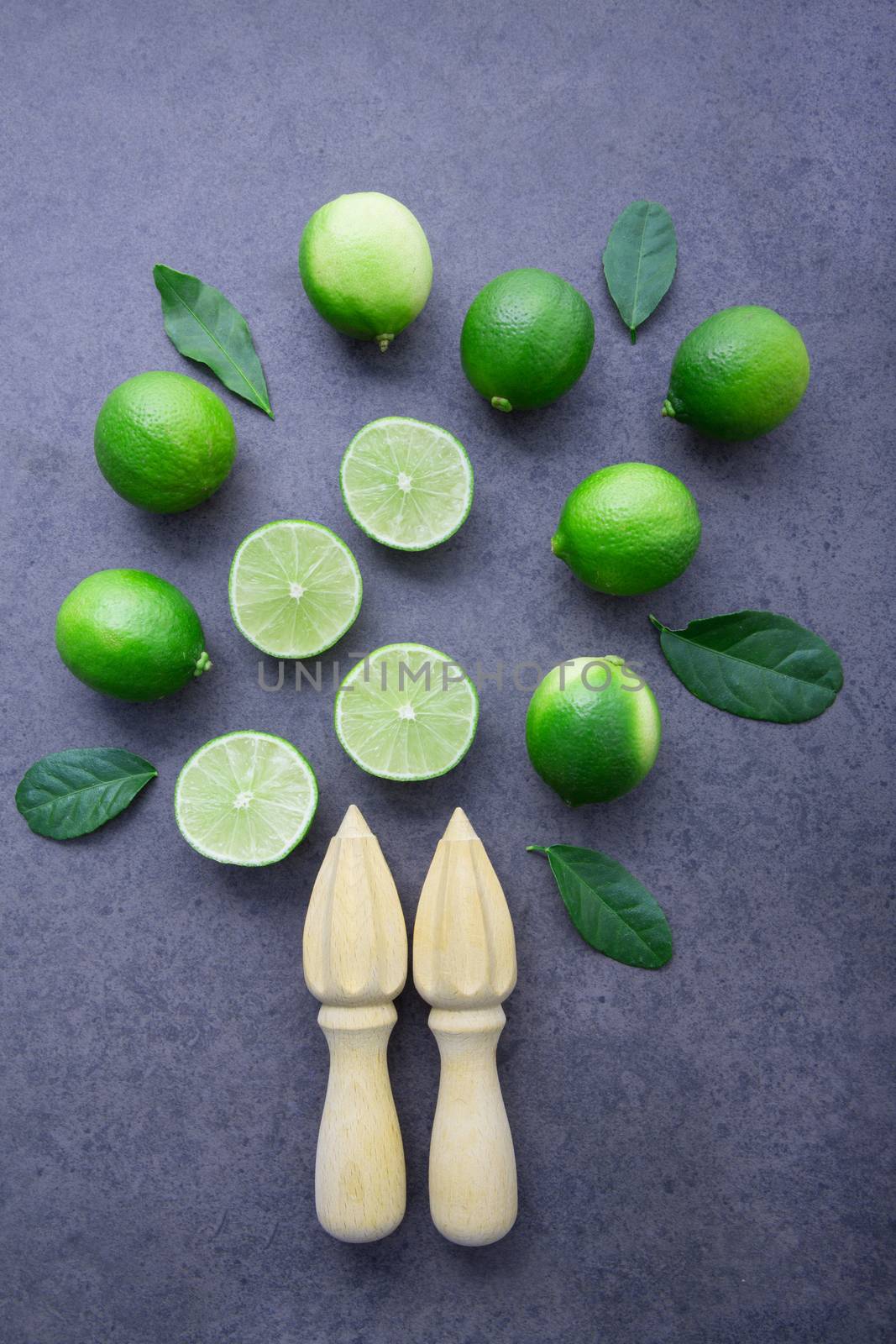 Fresh limes and wooden juicer on white background. Top view with by Bowonpat