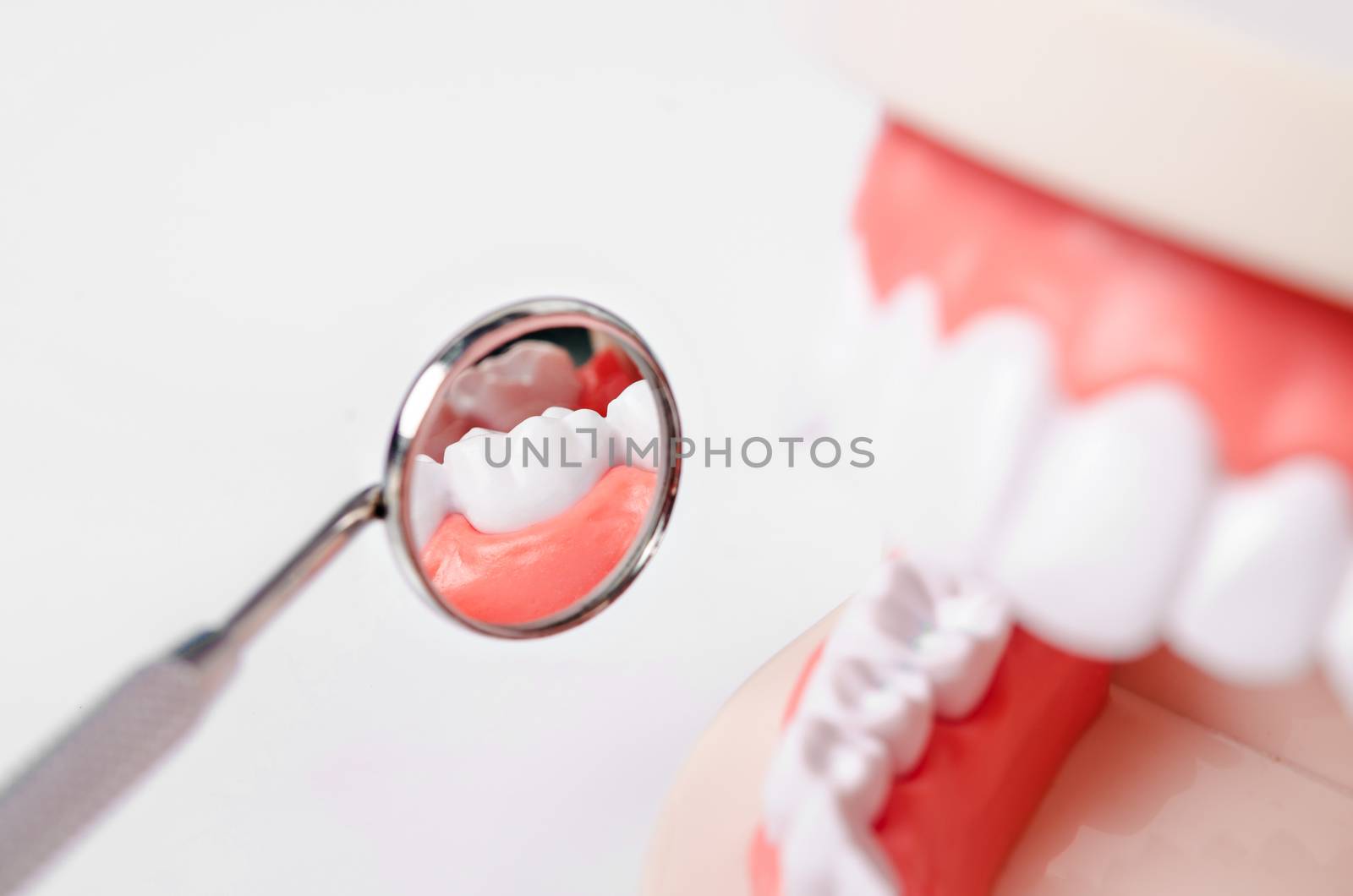 White teeth and dental instruments on white background.