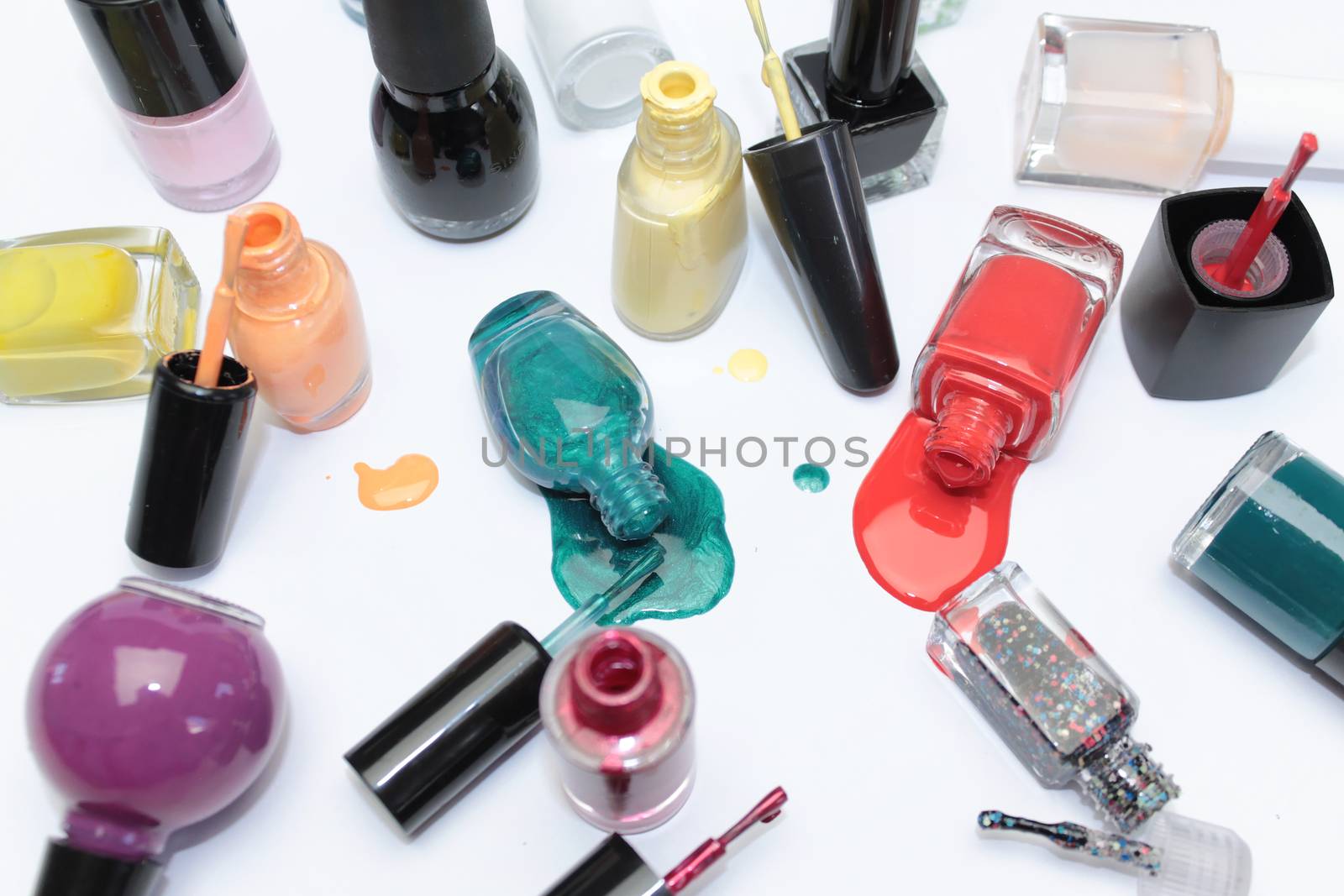 Nail polish assortment of bright colors on white background with colorful drops by Kasia_Lawrynowicz