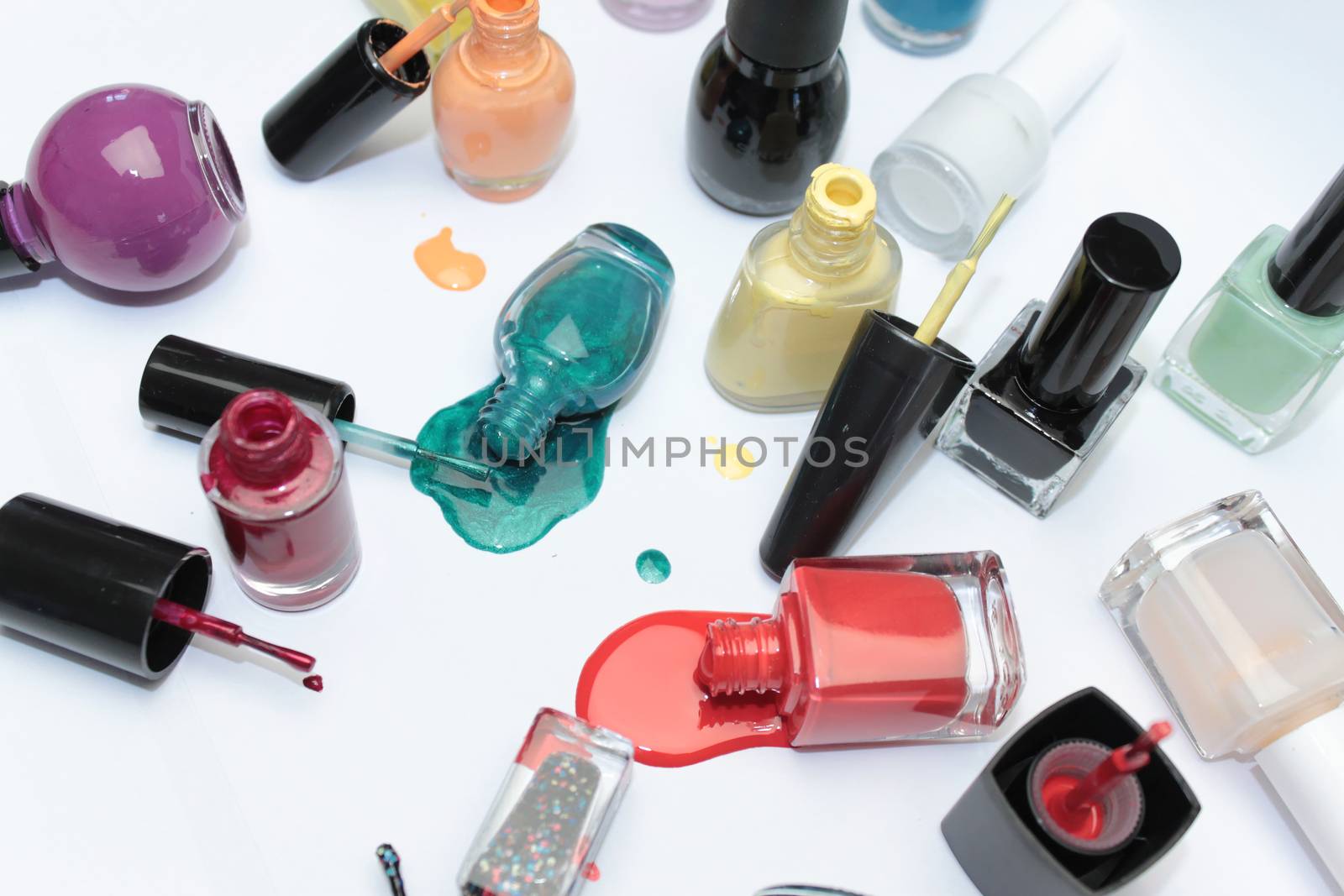 Nail polish assortment of bright colors on white background with colorful drops by Kasia_Lawrynowicz