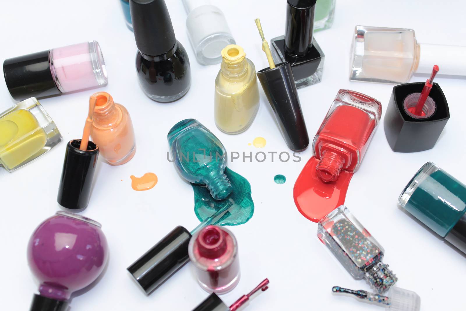 Nail polish assortment of bright colors on white background with colorful drops by Kasia_Lawrynowicz