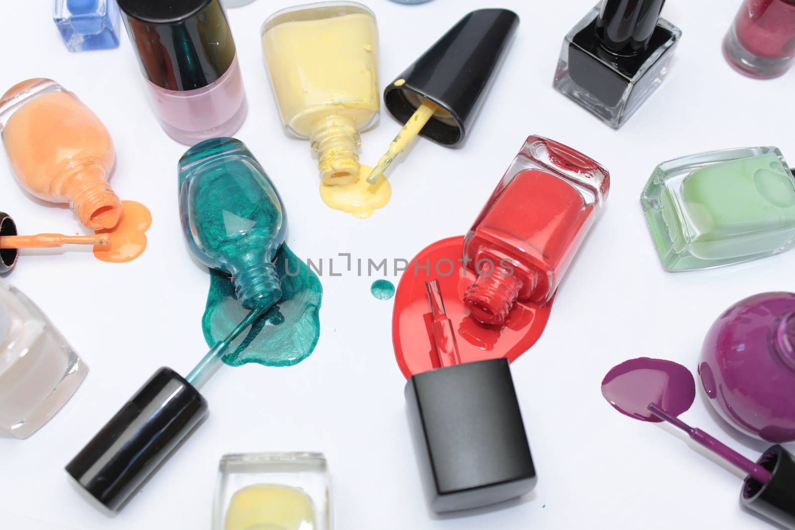 Nail polish assortment of bright colors on white background with colorful drops by Kasia_Lawrynowicz