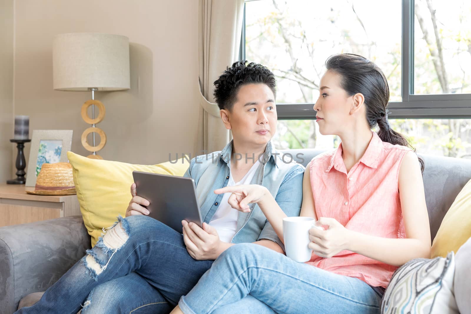 Young Couples using tablet tohether in living room of contemporary house for modern lifestyle concept