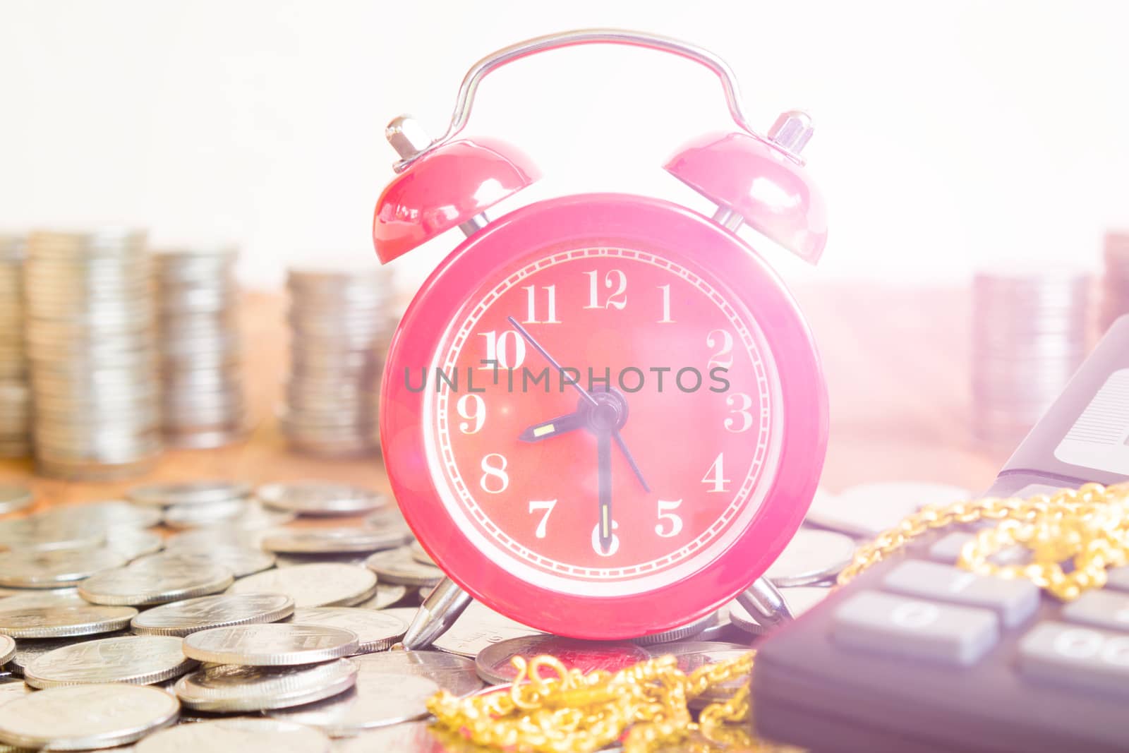 Stack Of Coins With Red Fashioned Alarm Clock For Display Planni by rakoptonLPN