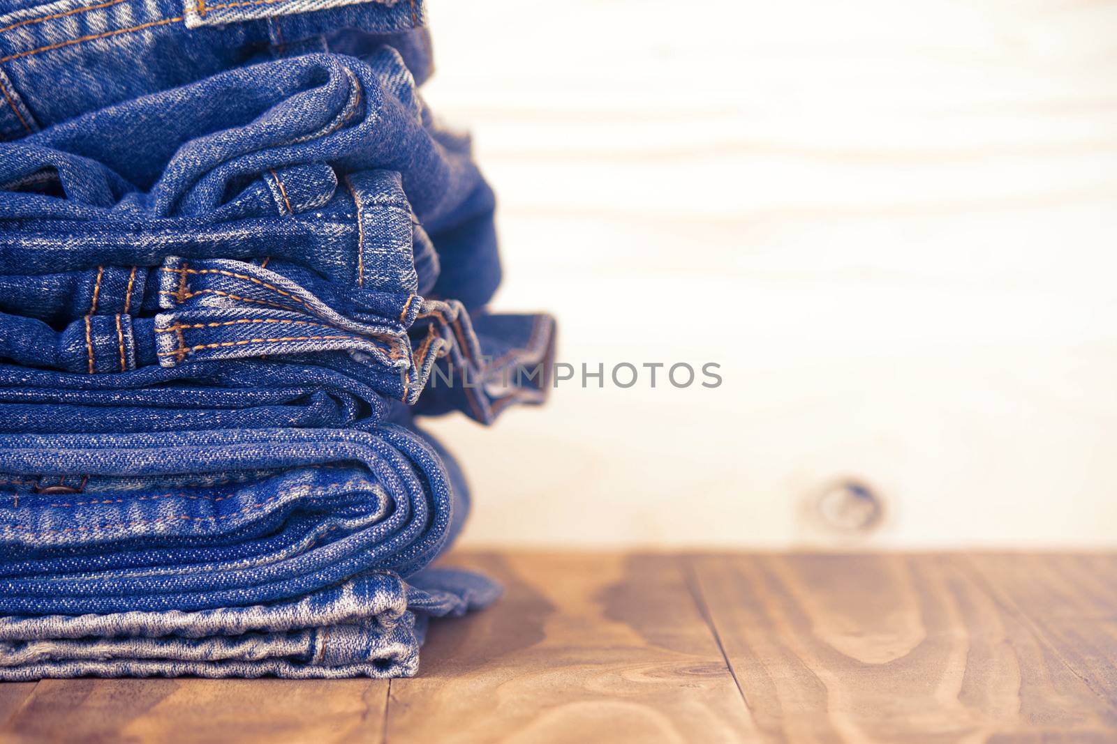 Stack Of Jeans On Old Wood Flooring, Fashion Concept  by rakoptonLPN