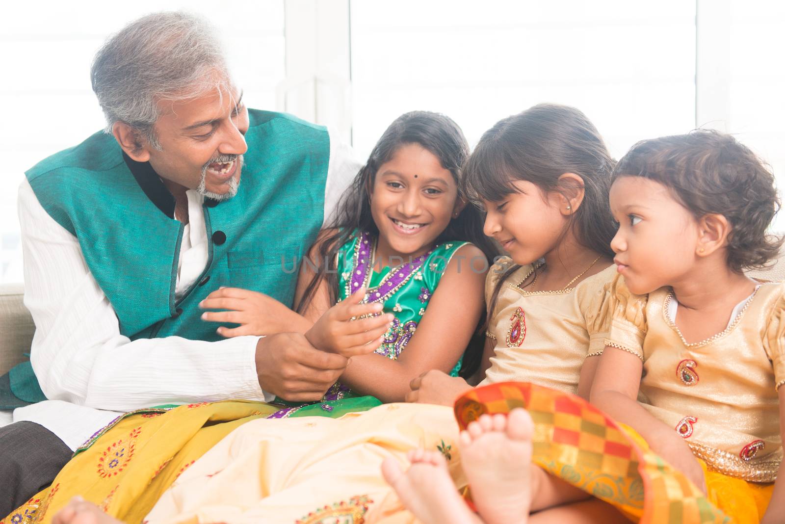 Portrait of beautiful Indian family playing at home. Happy Asian father and children indoors lifestyle.