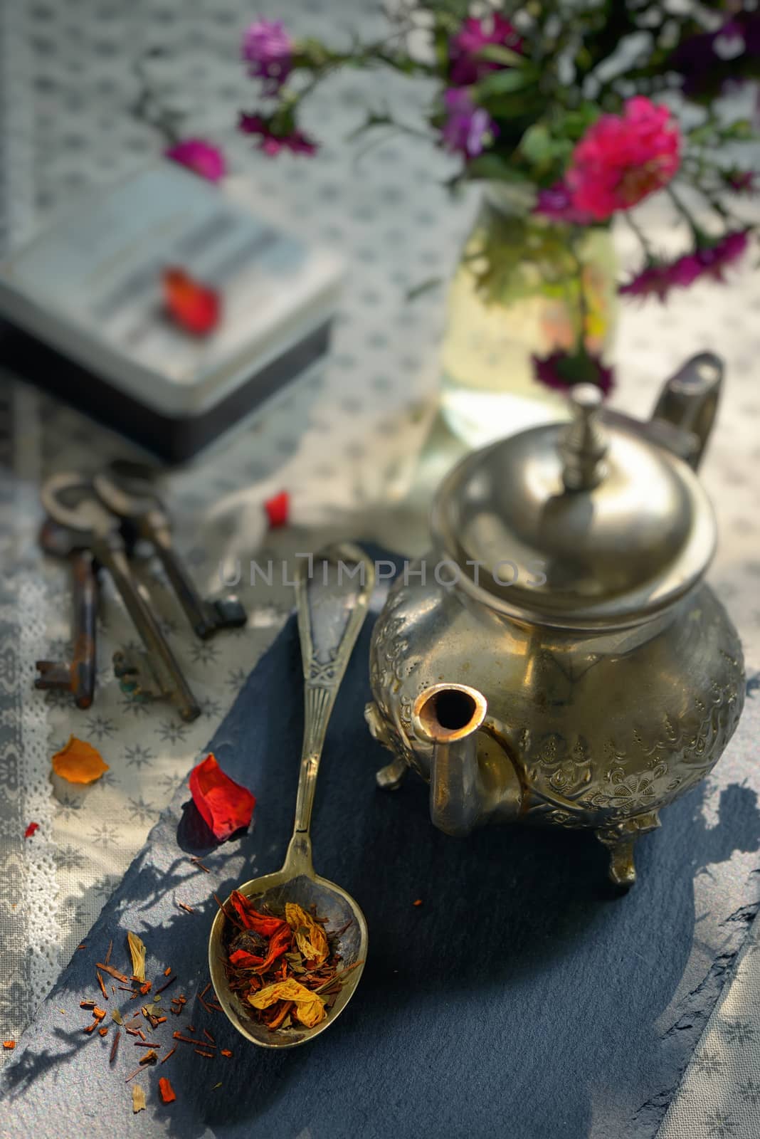 Dry tea leaves on spoon on ardesia plate