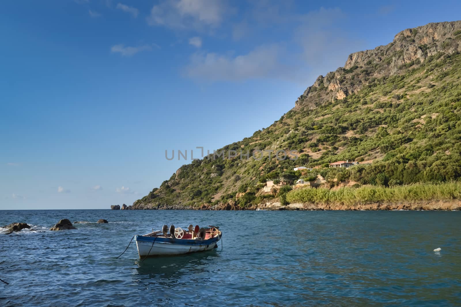 Panorama on the ocean and a traditional fishing boat in the village of Paralia in western Crete