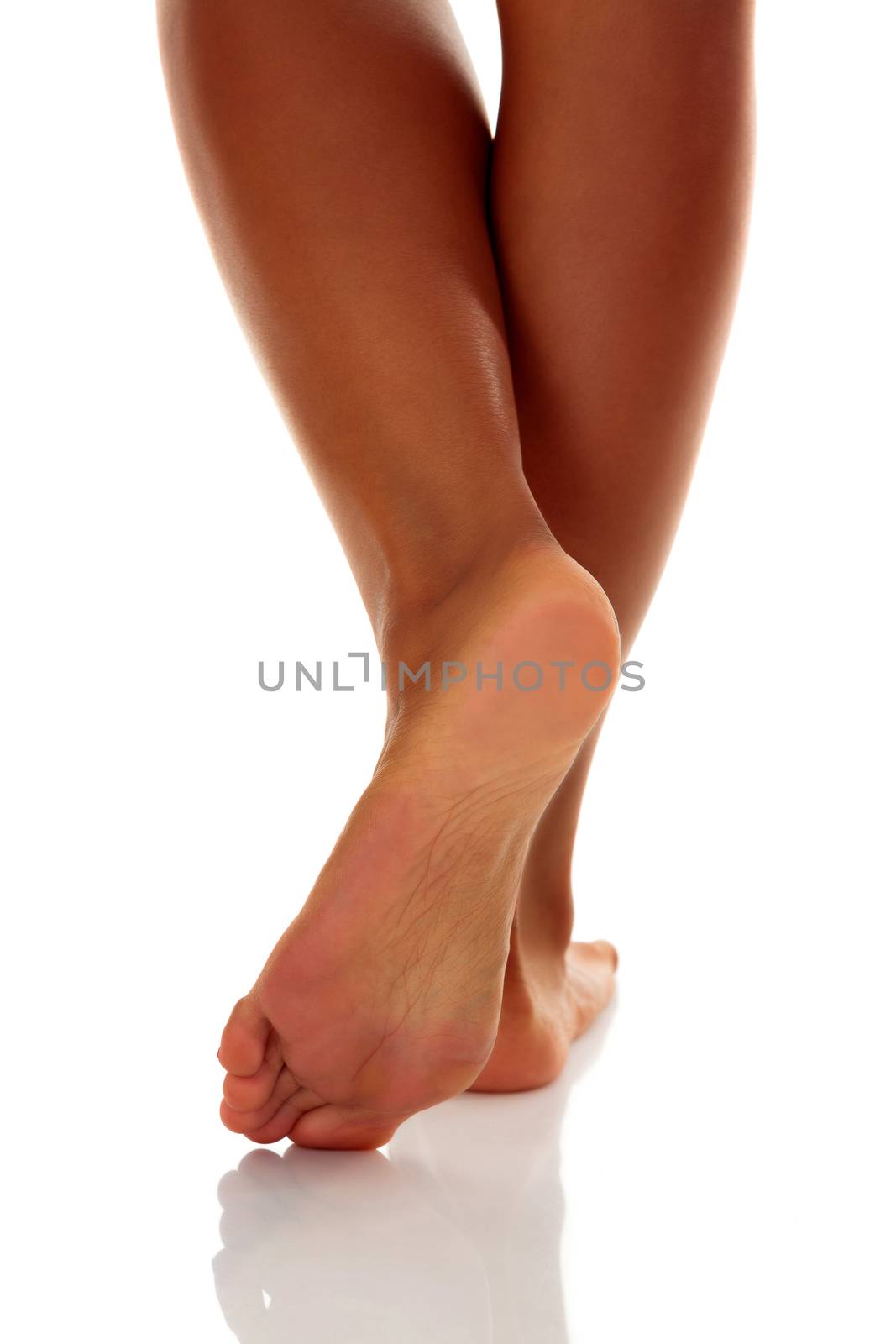 Closeup shot of tanned female feet, isolated on white background by Nobilior