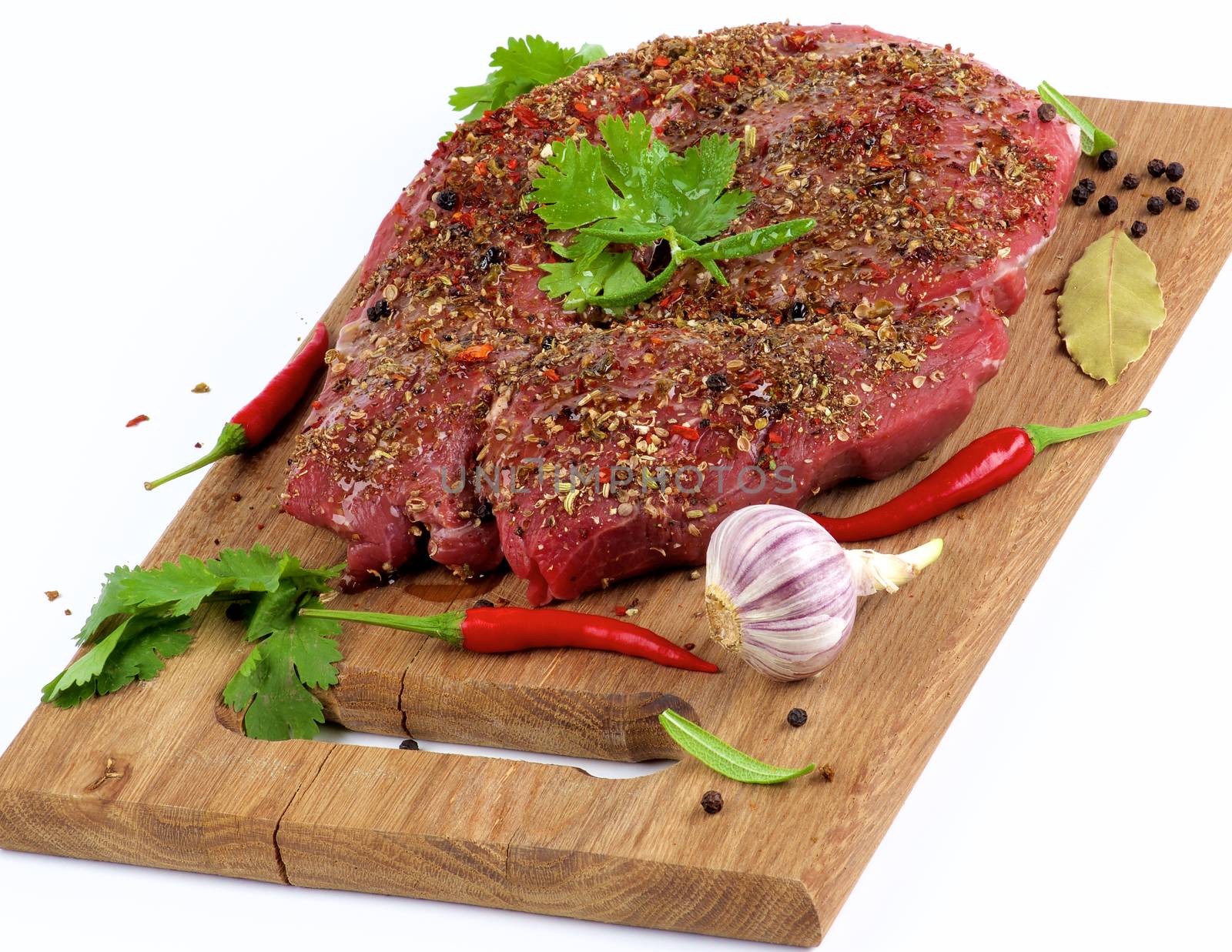 Marinated Raw Boneless Beef Shank with Herbs and Spices, Garlic and Chili Pepper on Wooden Cutting Board closeup on White background