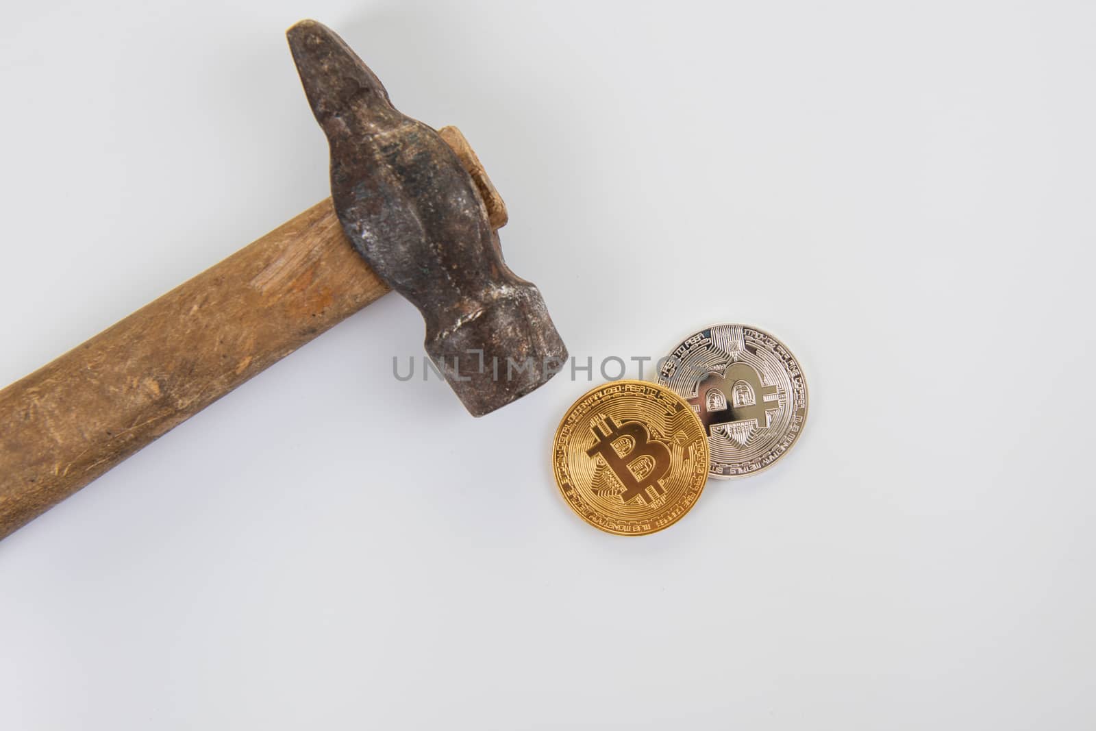 An old hammer and smartphone with broken screen on a white background