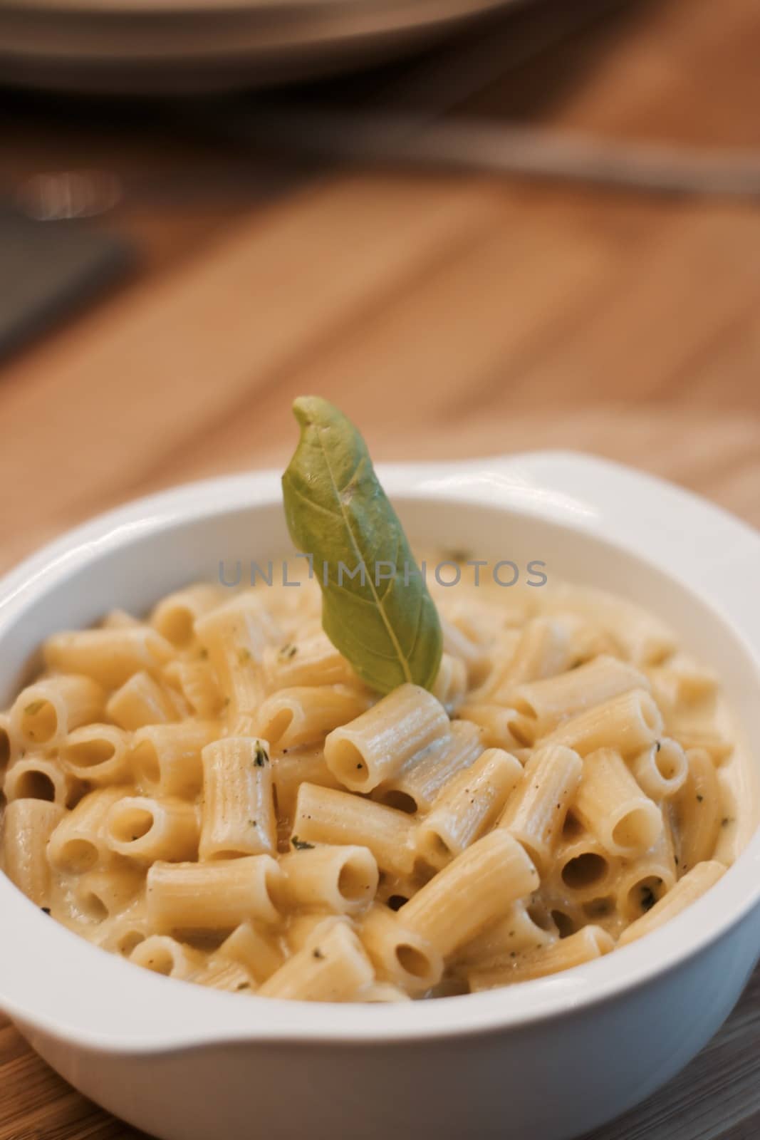 Delicious and fresh pasta on white plate on wooden board in the kitchen. Cooking concept.