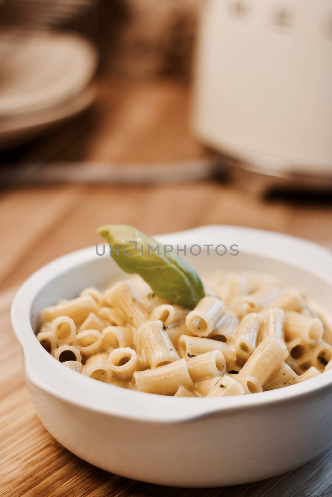 Delicious and fresh pasta on white plate on wooden board in the kitchen. Cooking concept.